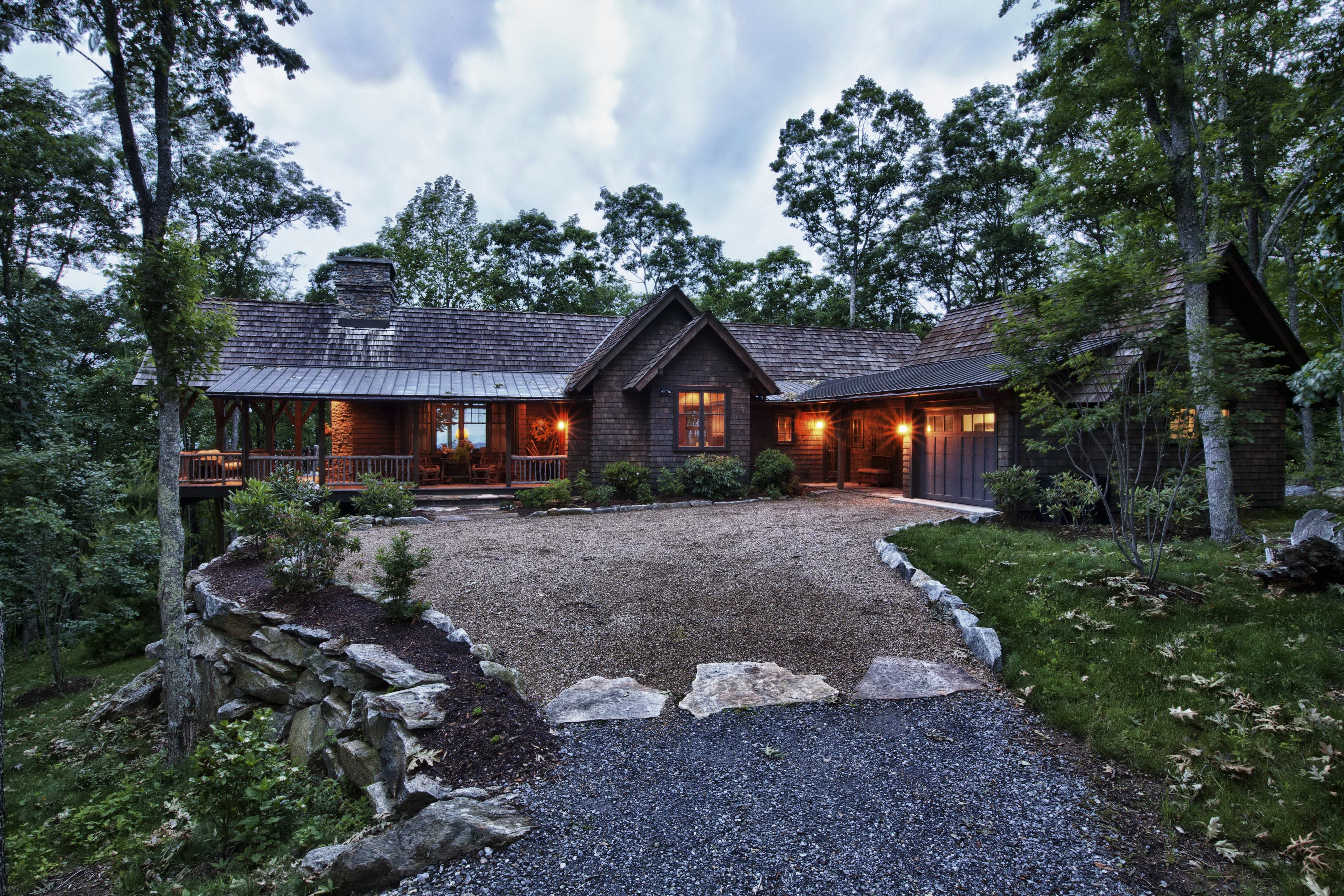 Rustic wooden house with a gravel driveway in a forest HD Wallpaper
