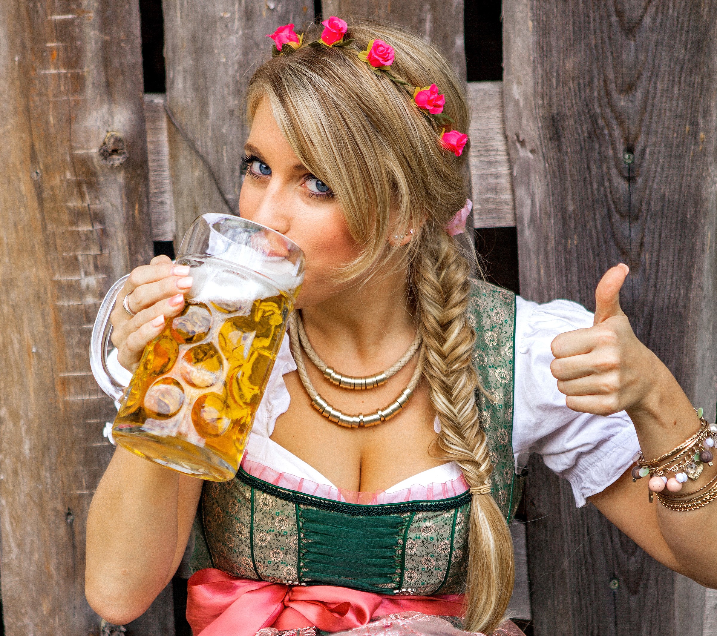 Woman in Dirndl drinking beer and giving thumbs up HD Wallpaper
