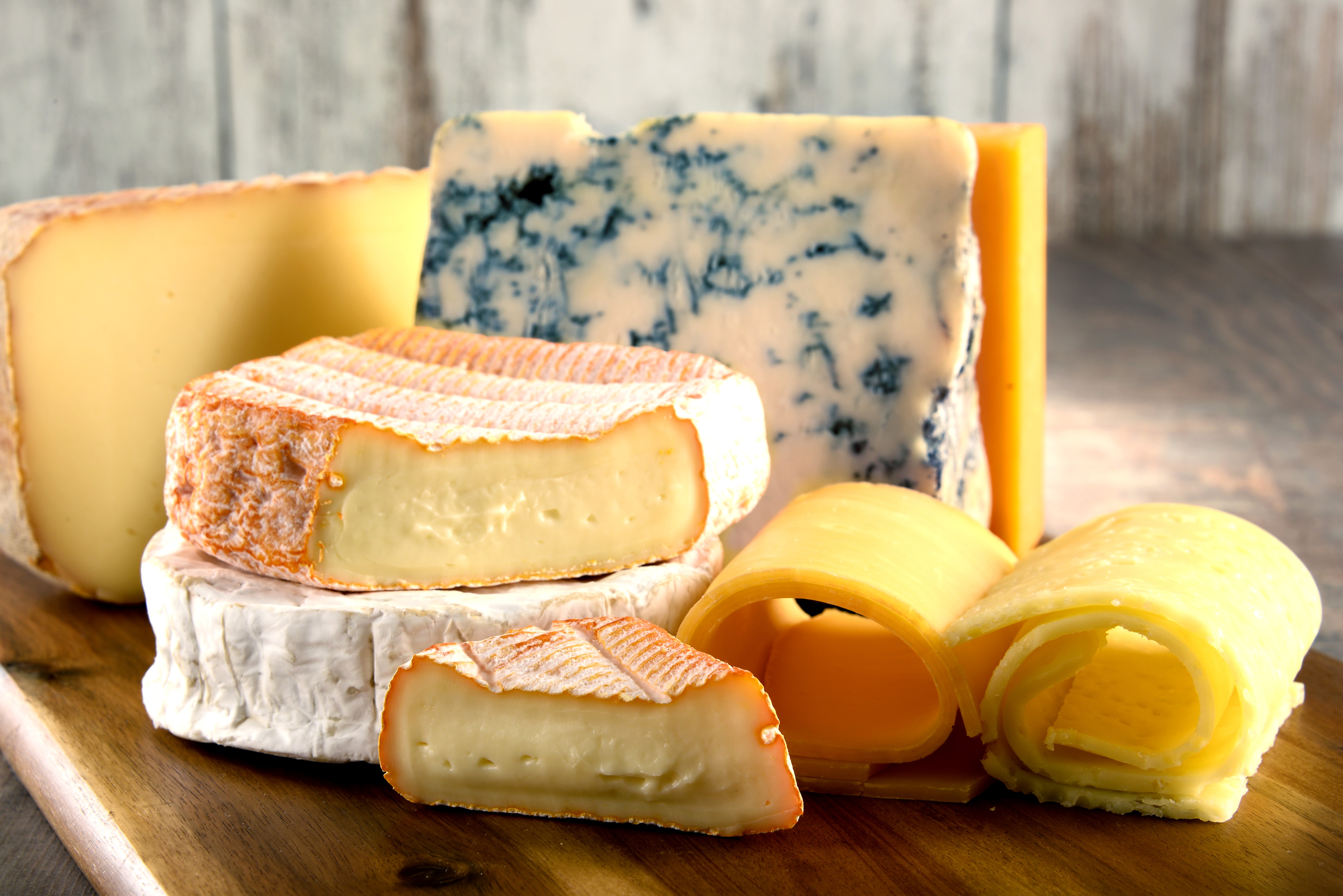 Assortment of Cheeses on a Wooden Board HD Wallpaper
