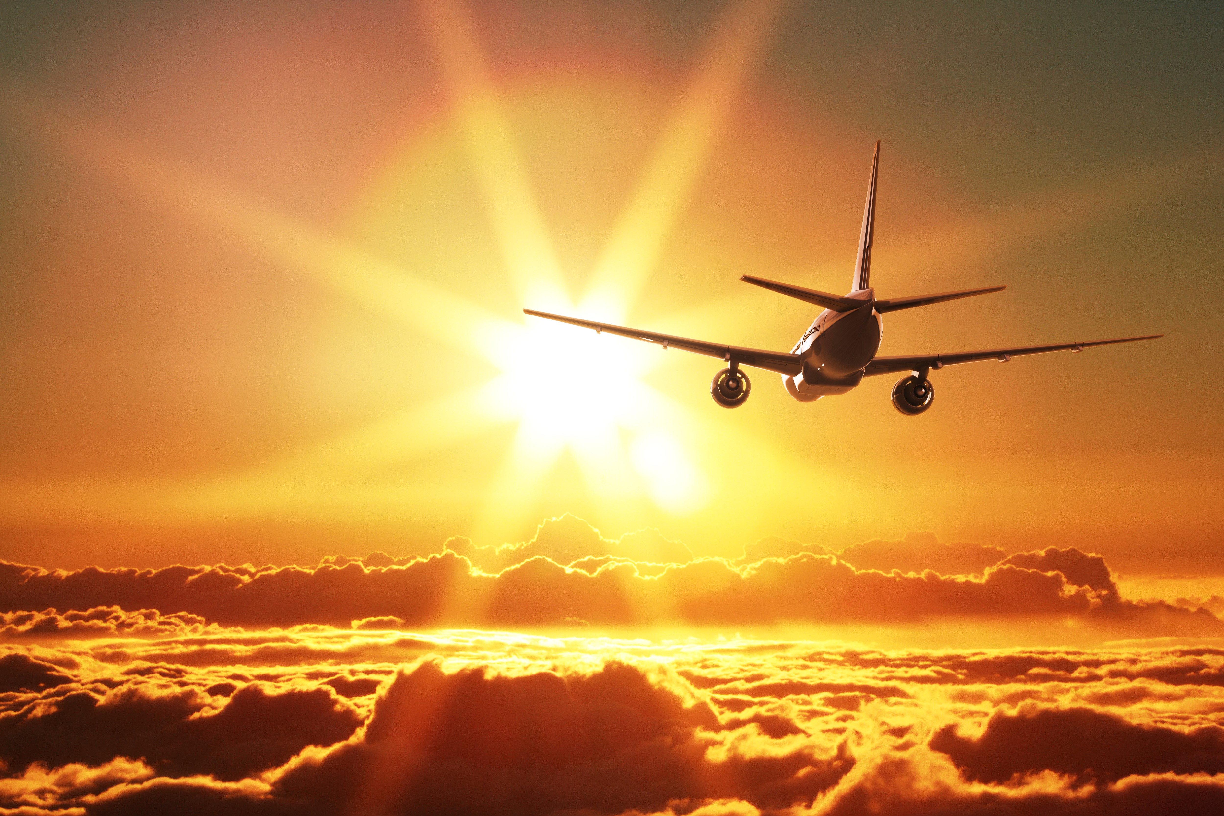 Airplane flying above clouds at sunset HD Wallpaper