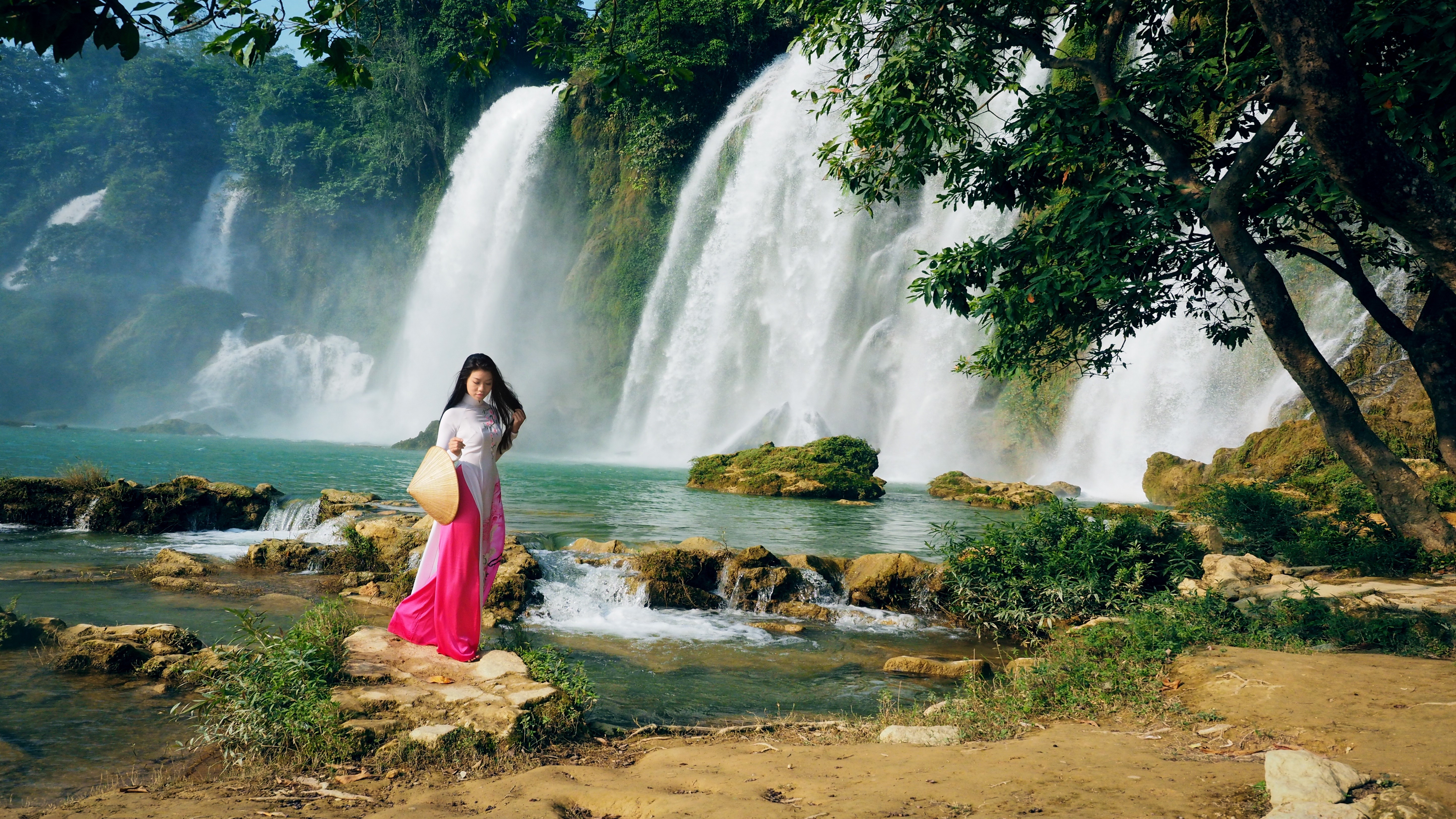 Woman in traditional dress at Ban Gioc Waterfall HD Wallpaper