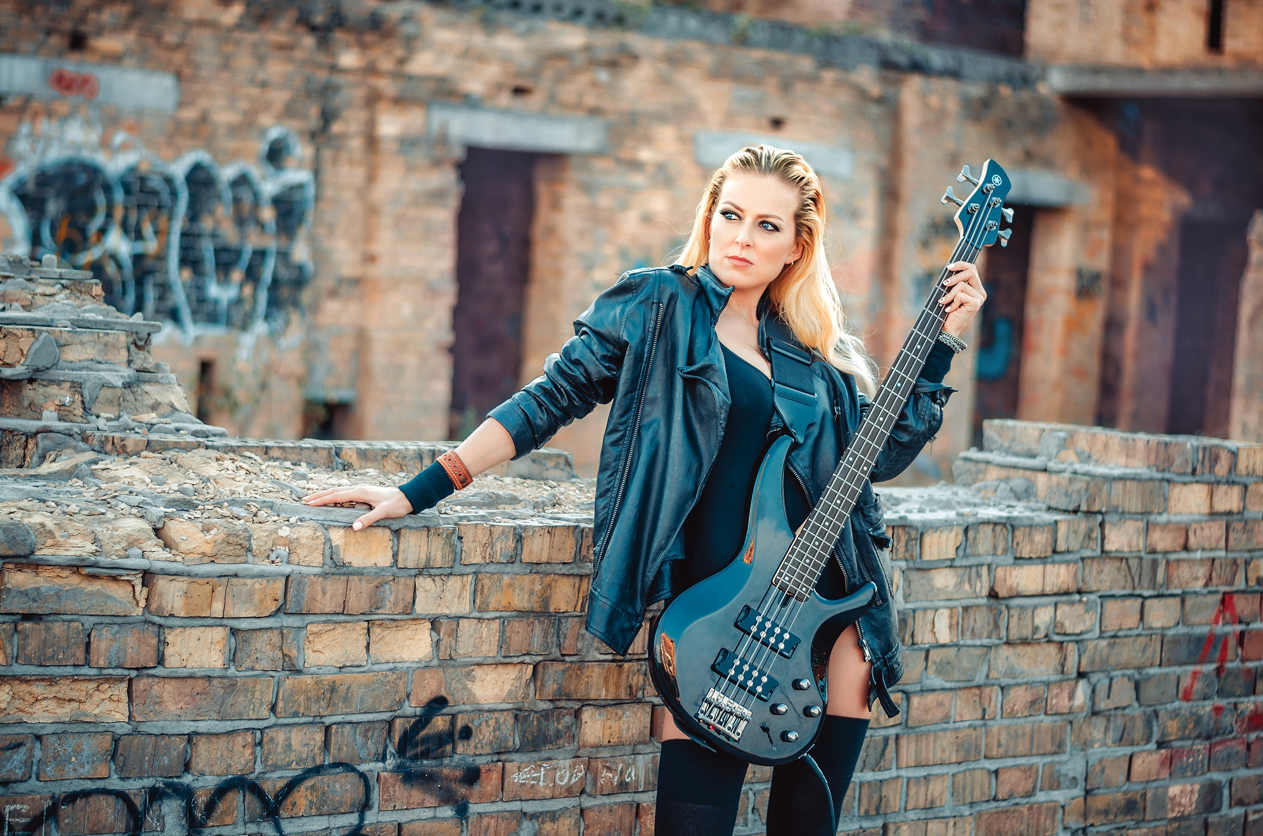 Blonde woman with bass guitar in urban ruins HD Wallpaper