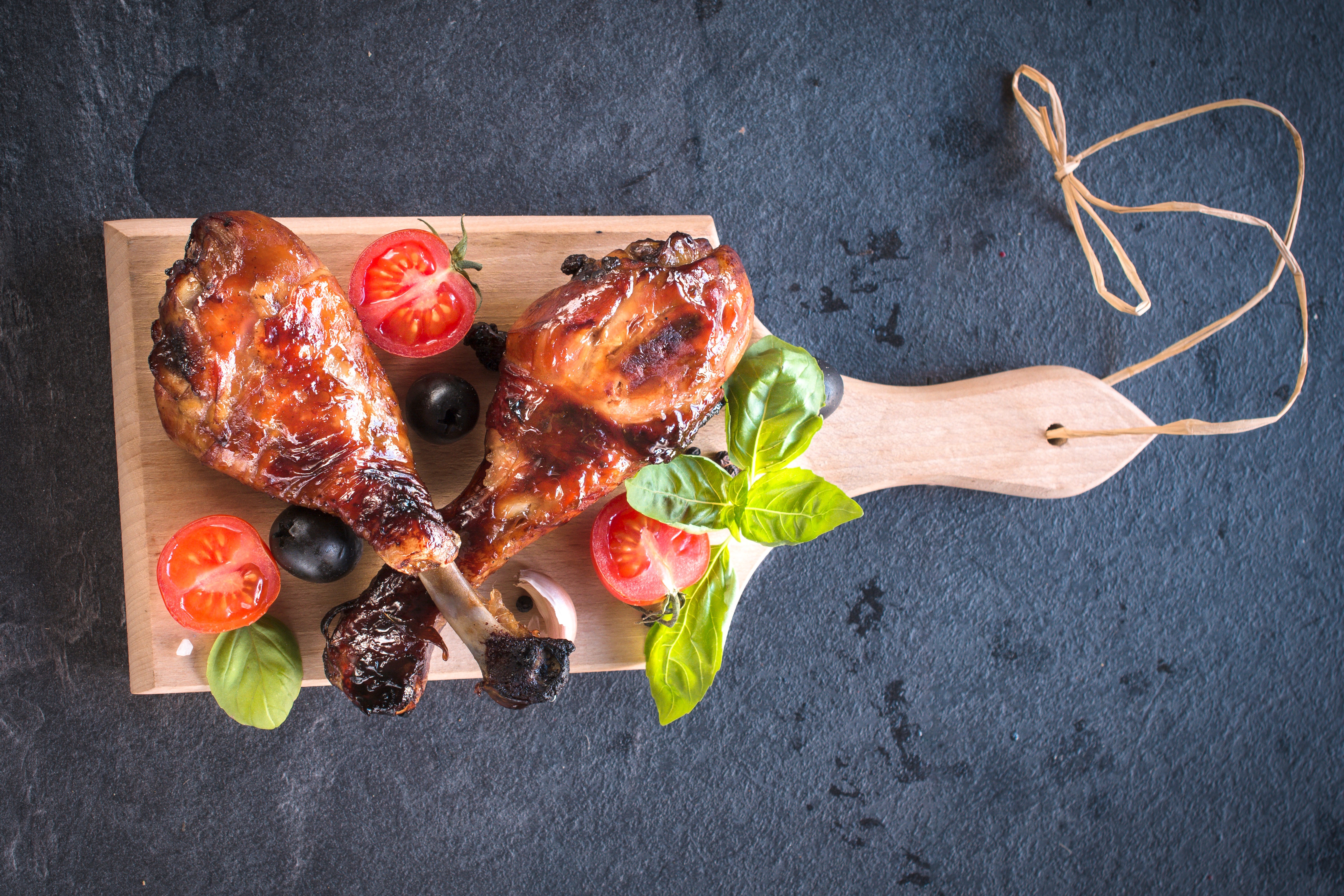 Roast Chicken legs with tomatoes and olives on a cutting board HD Wallpaper