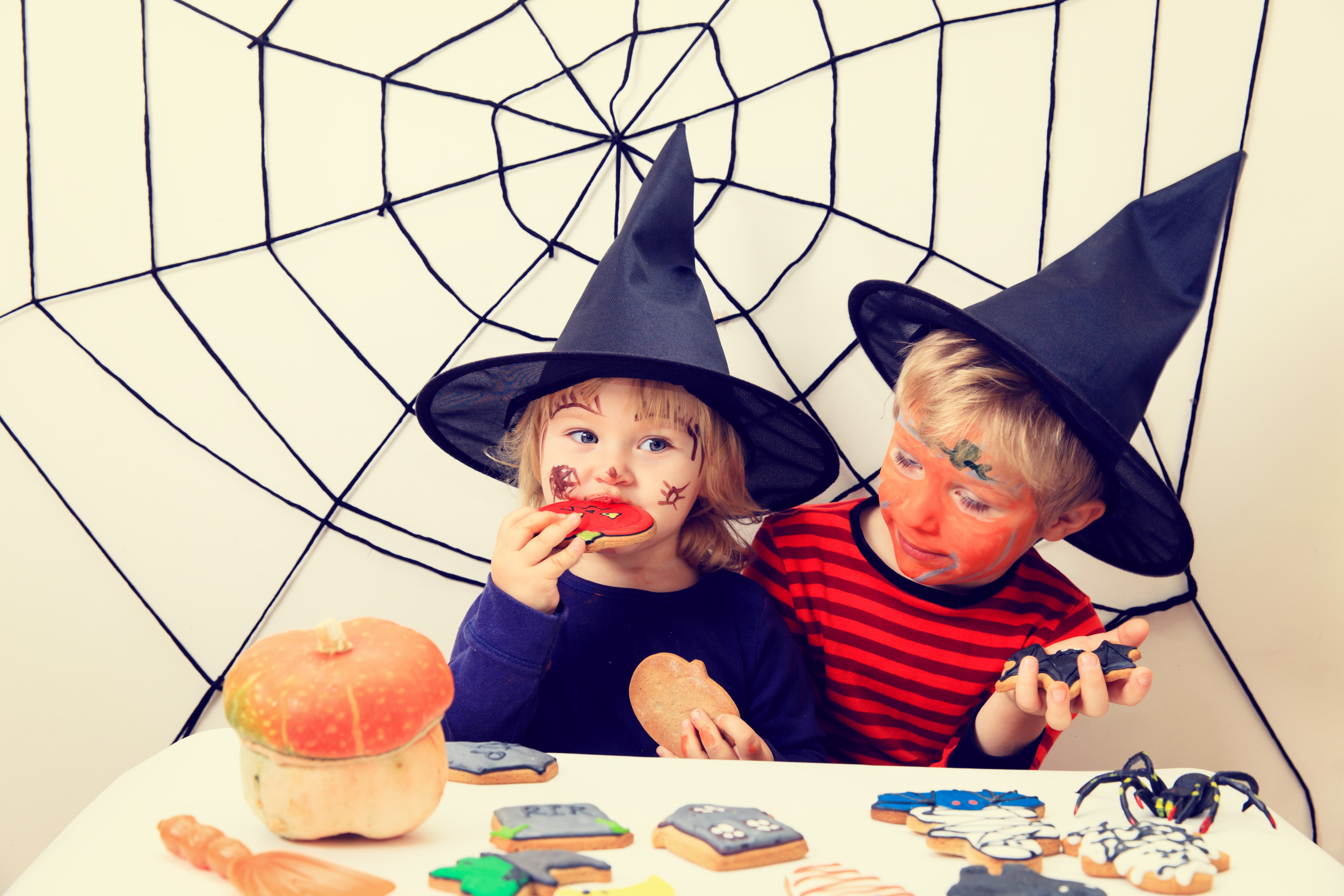 Two children in Halloween costumes with face paint and cookies HD Wallpaper