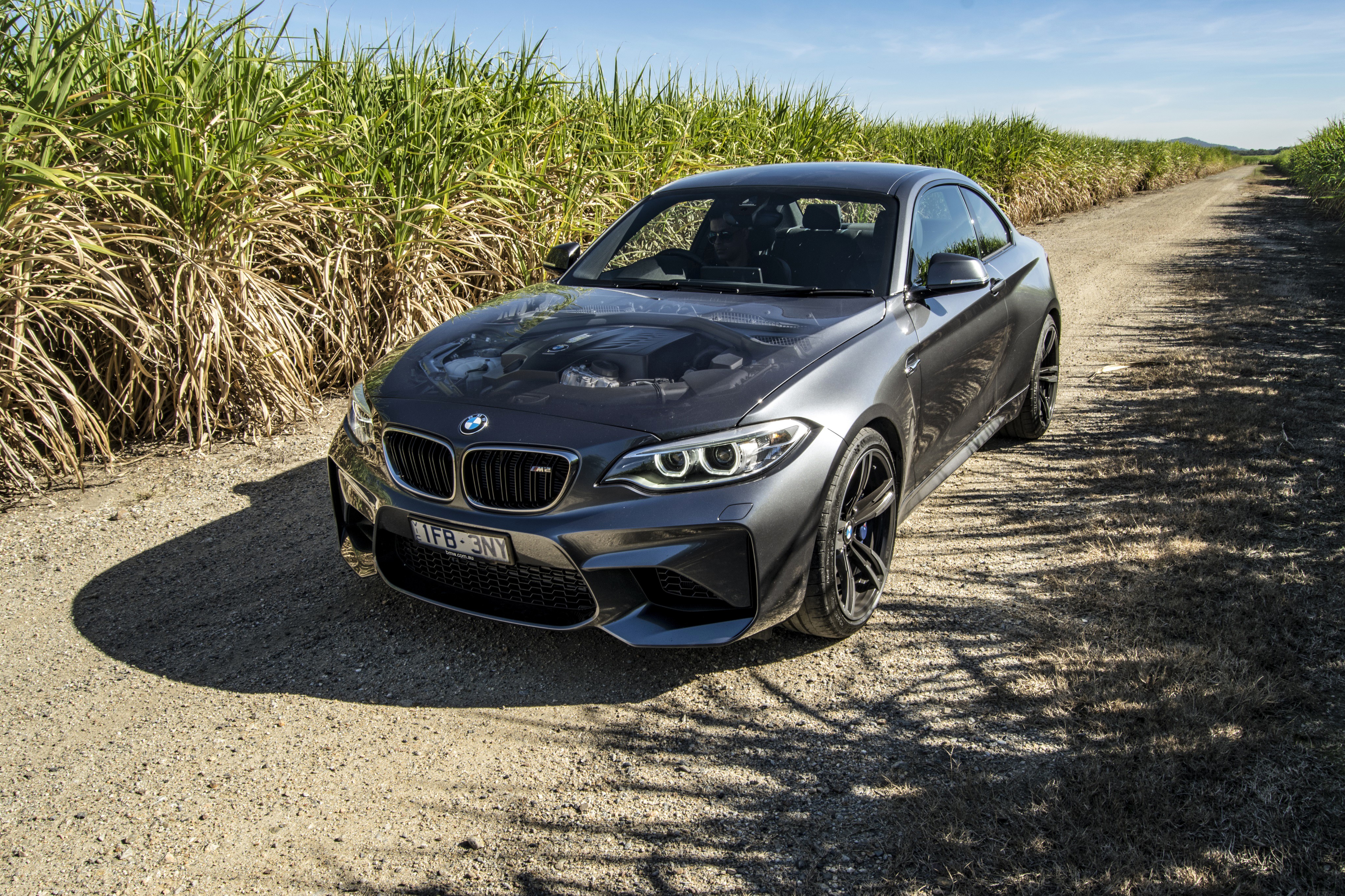 Grey 2016 BMW M2 Coupe on a dirt road HD Wallpaper