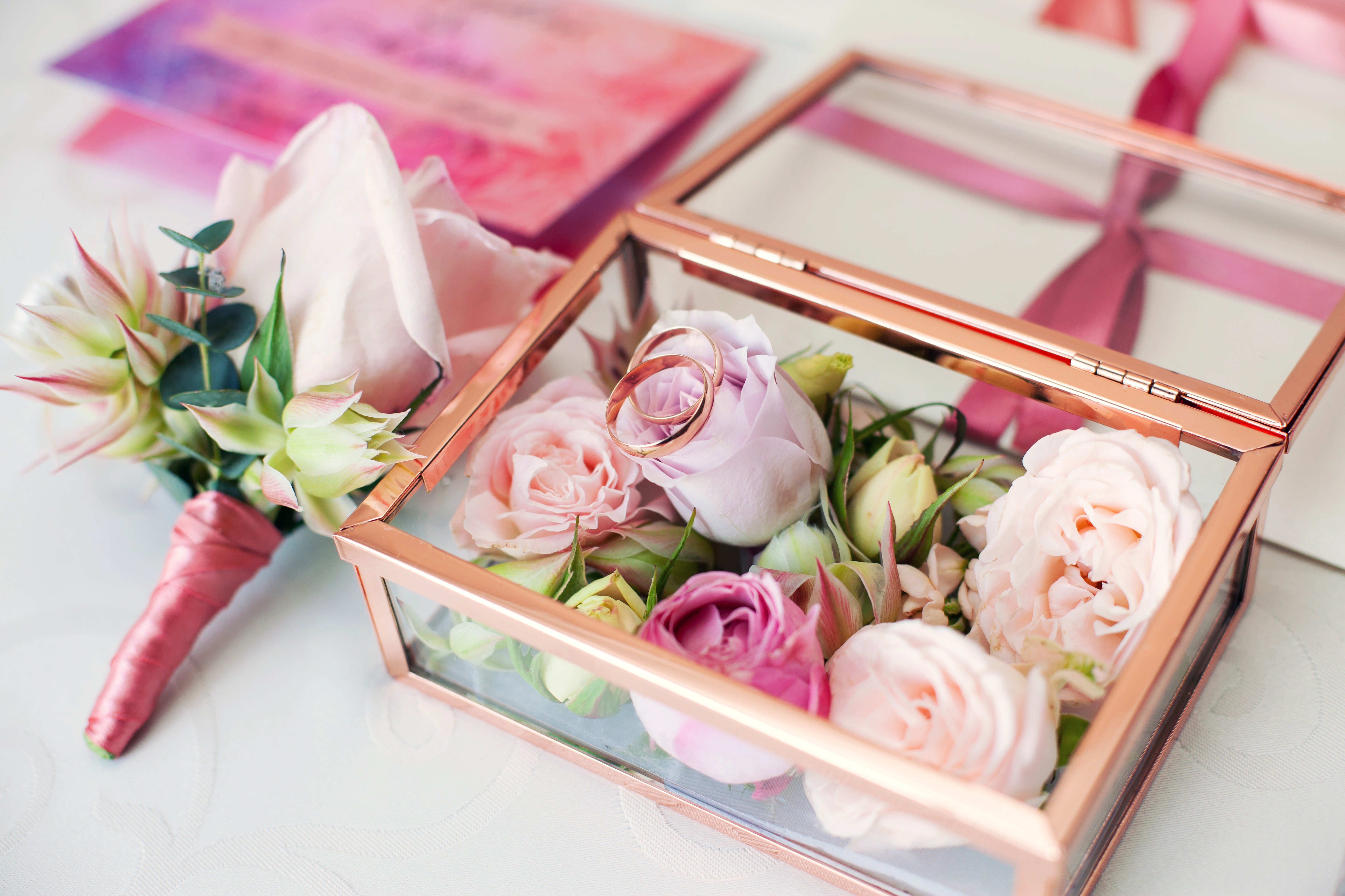 Wedding rings in a glass box with roses and boutonniere HD Wallpaper