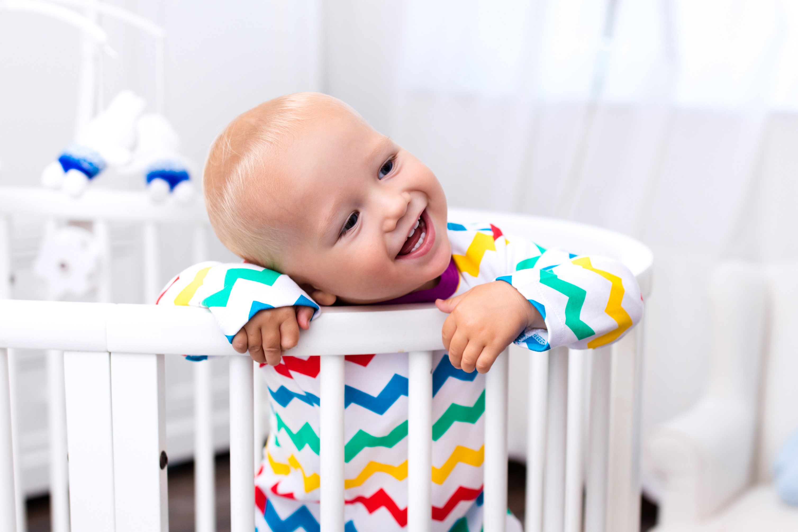 Baby smiling in a crib HD Wallpaper