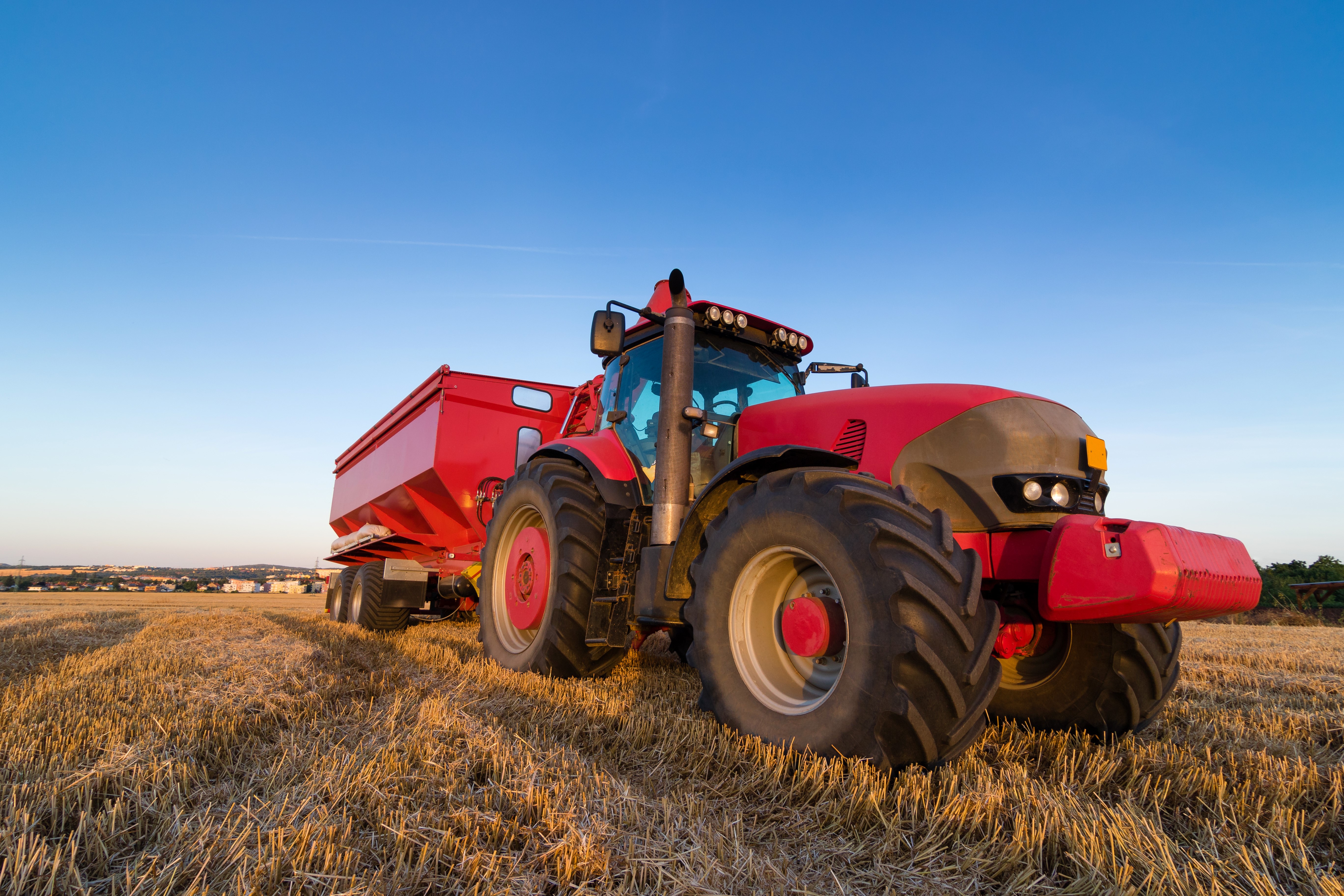 Red tractor with trailer in a field HD Wallpaper