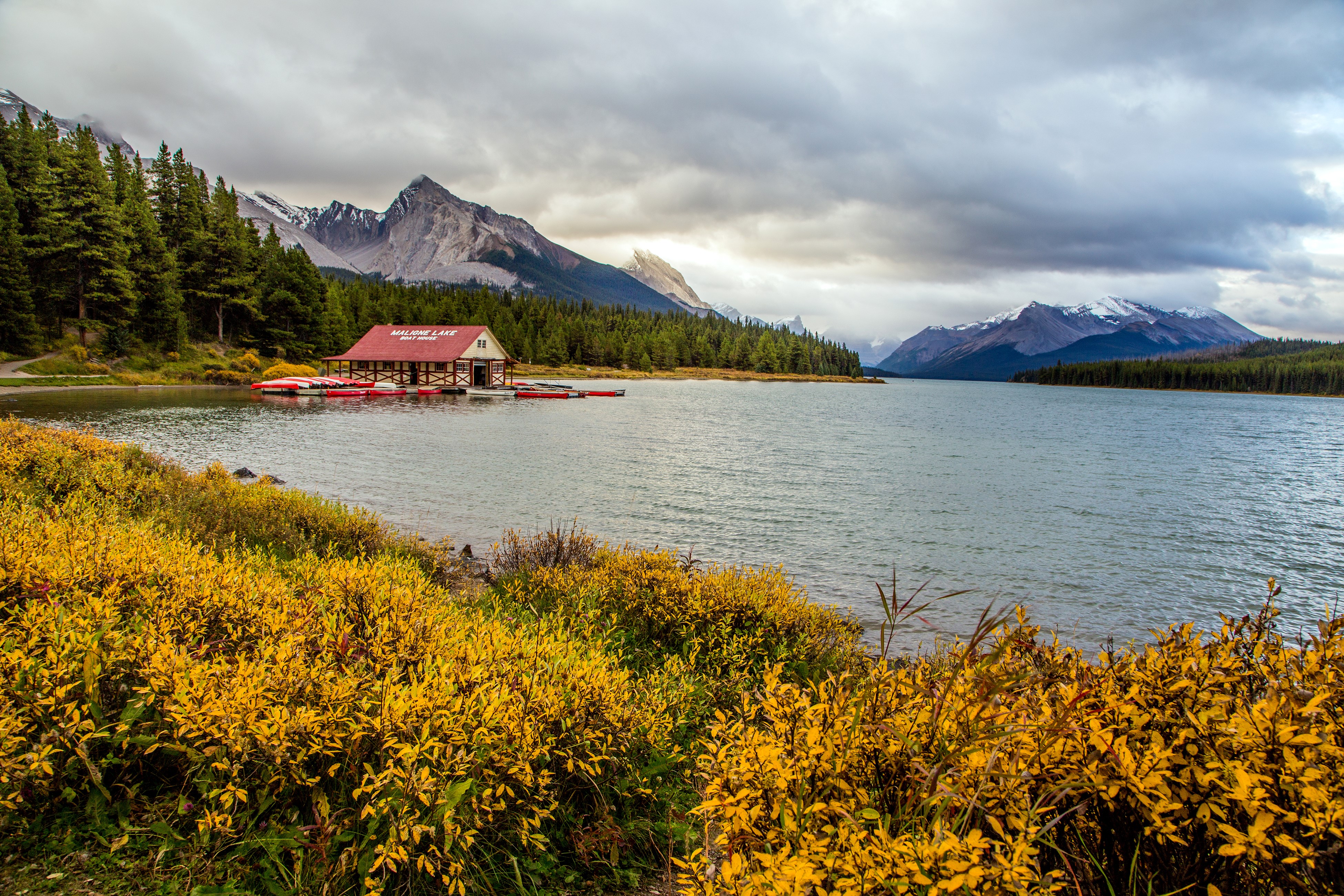 Maligne Lake Boathouse with Canoes and Mountains HD Wallpaper