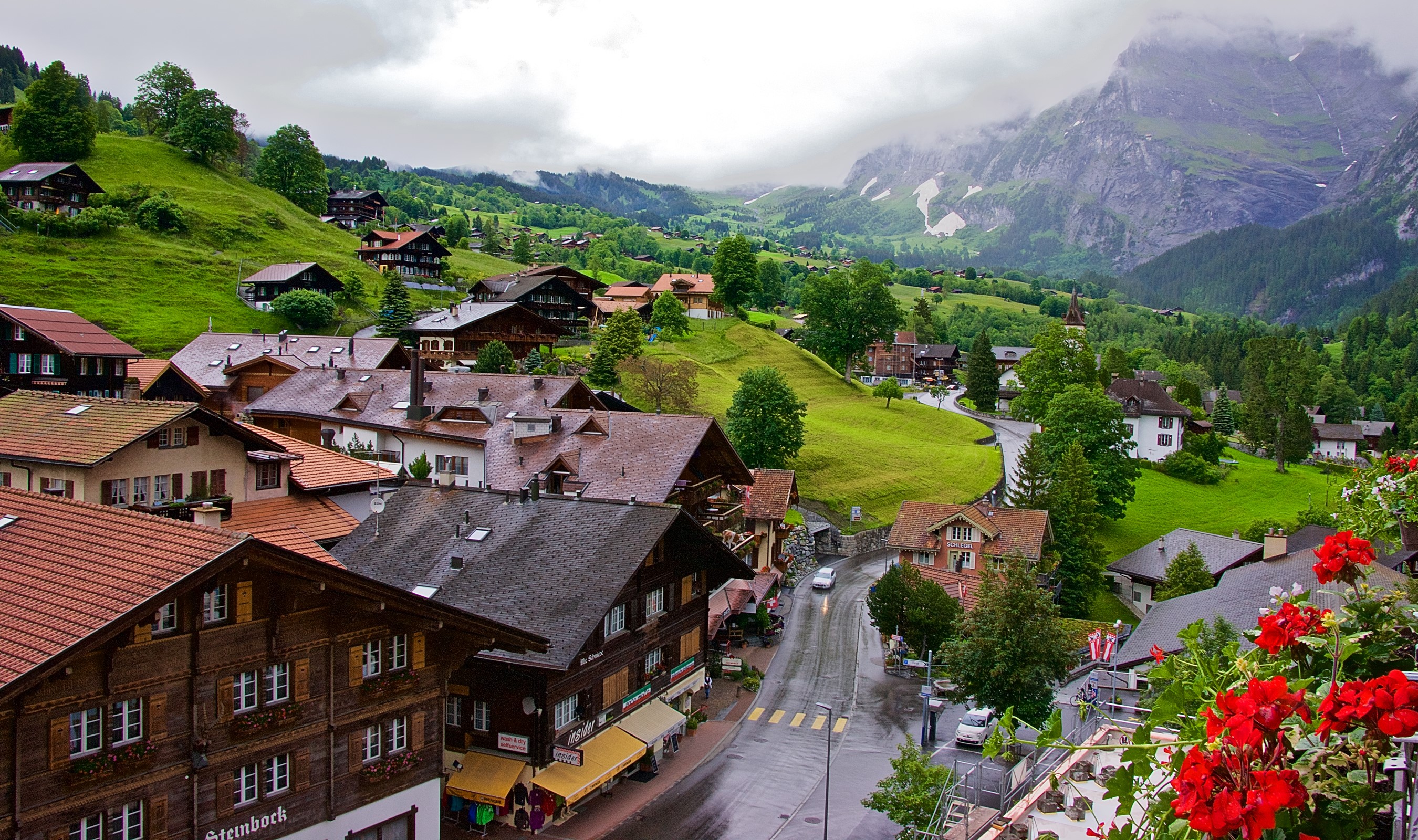 Grindelwald, Switzerland: Houses on a green hillside with mountains HD Wallpaper
