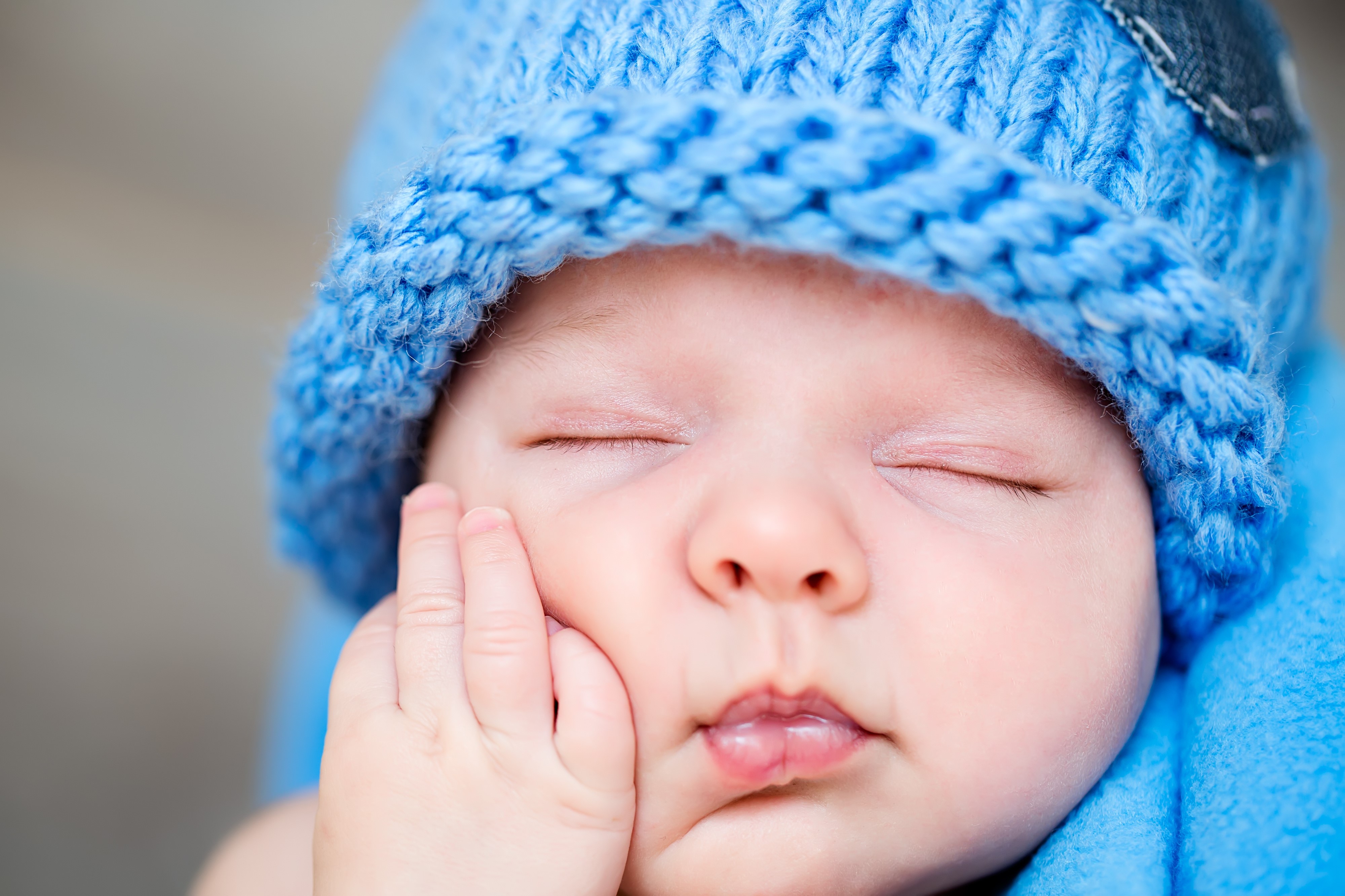 Baby wearing a blue knitted winter hat HD Wallpaper