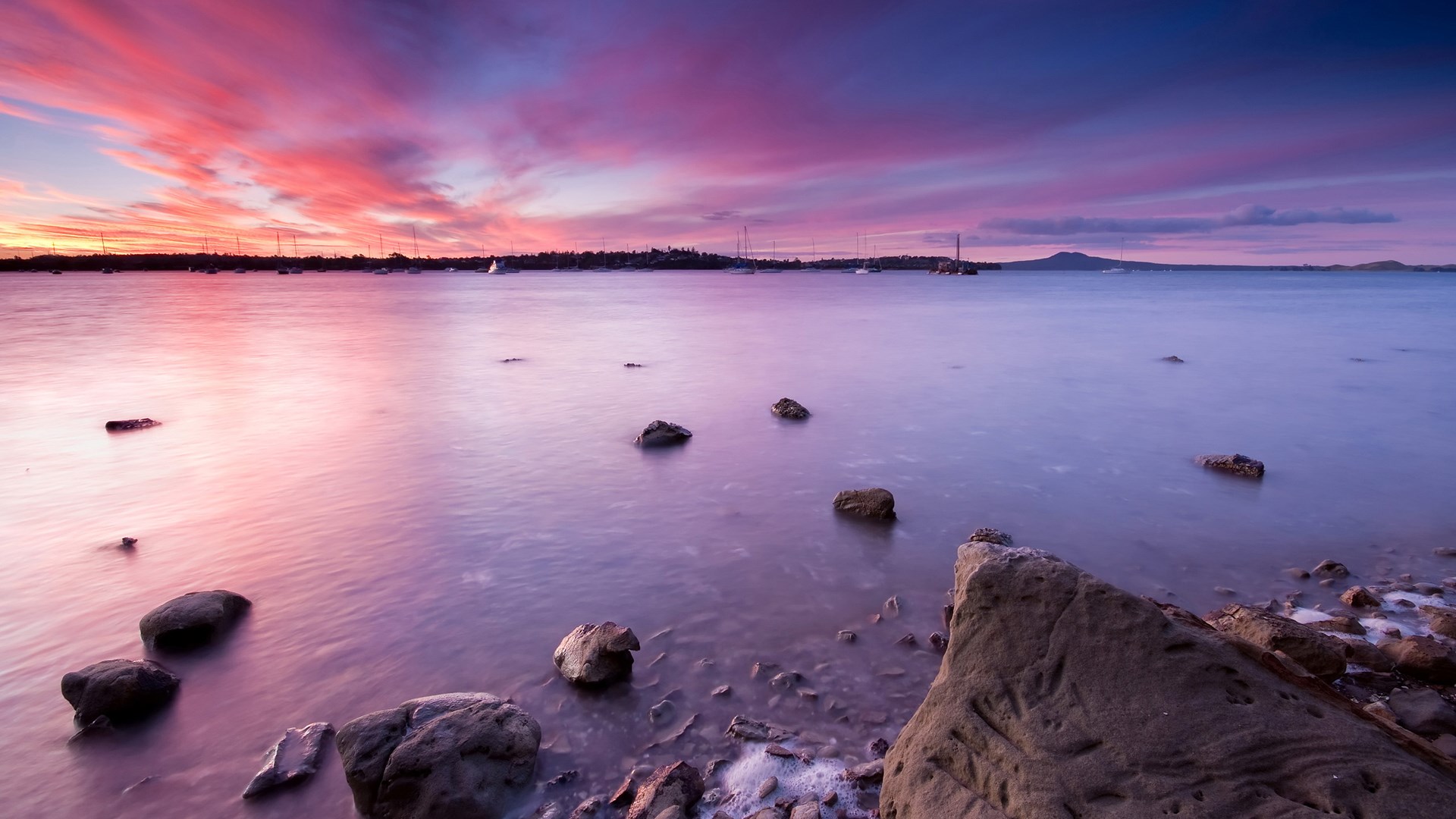Sunset over a calm bay with boats and islands HD Wallpaper