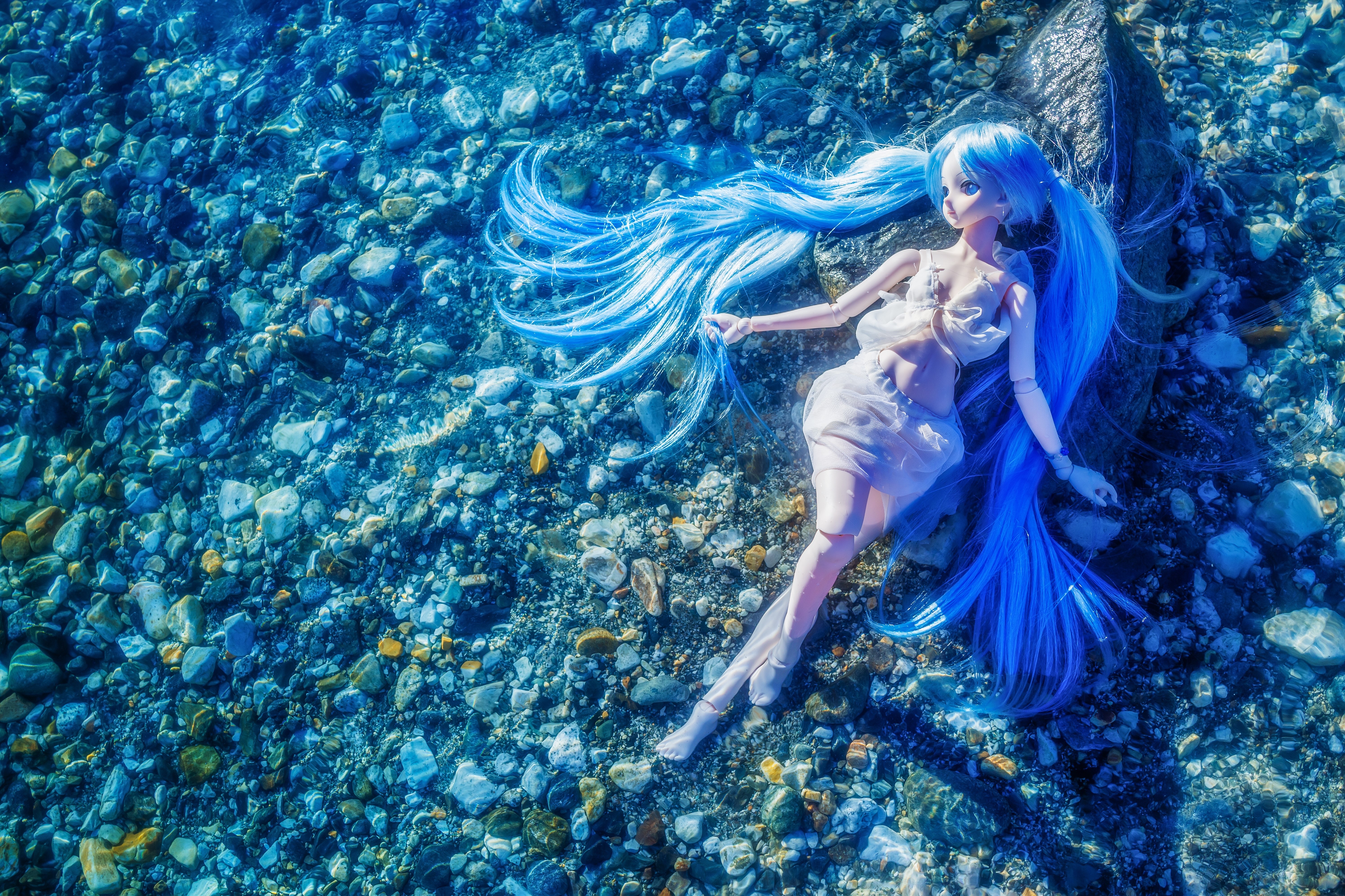 Doll with blue hair underwater on stones HD Wallpaper