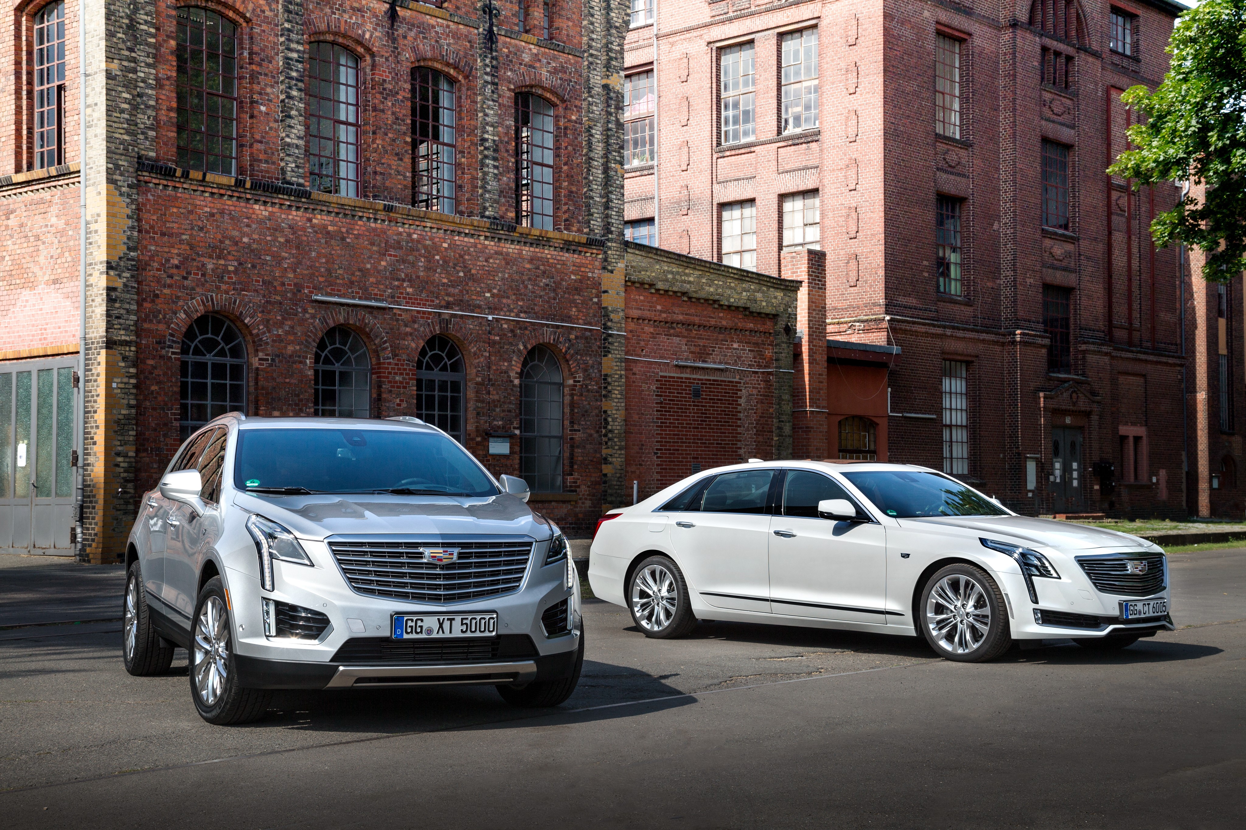 Cadillac CT6 and XT5 parked in front of brick buildings HD Wallpaper