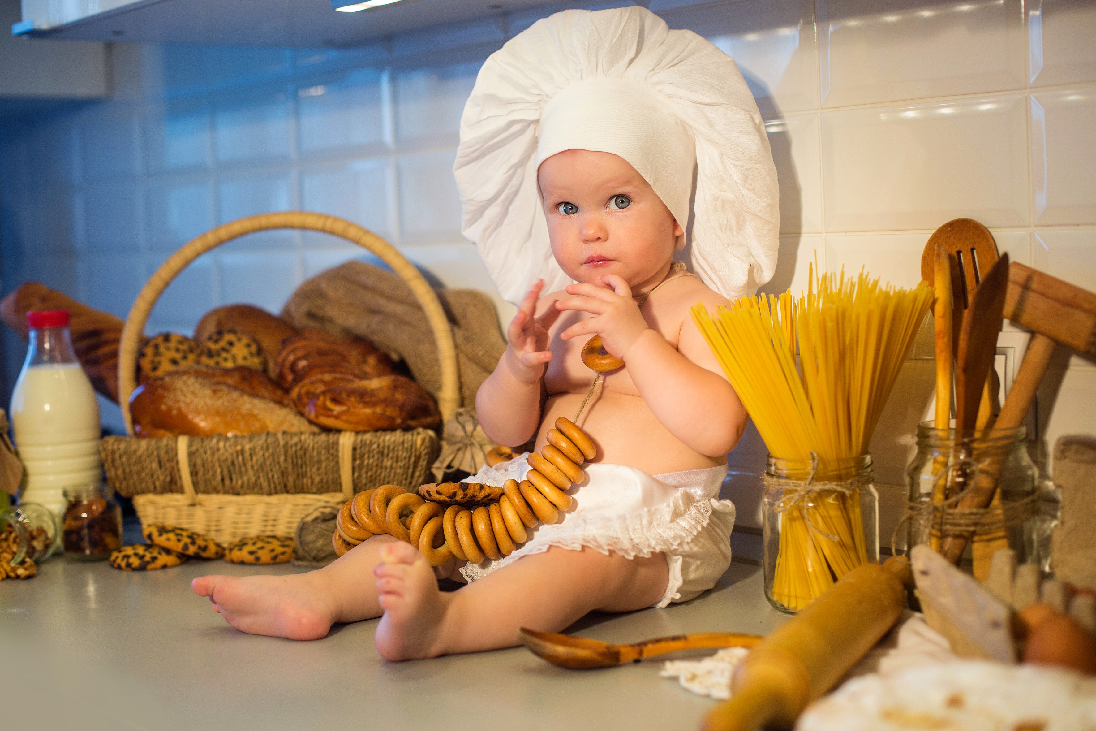 Baby in chef hat with bagels and pasta HD Wallpaper