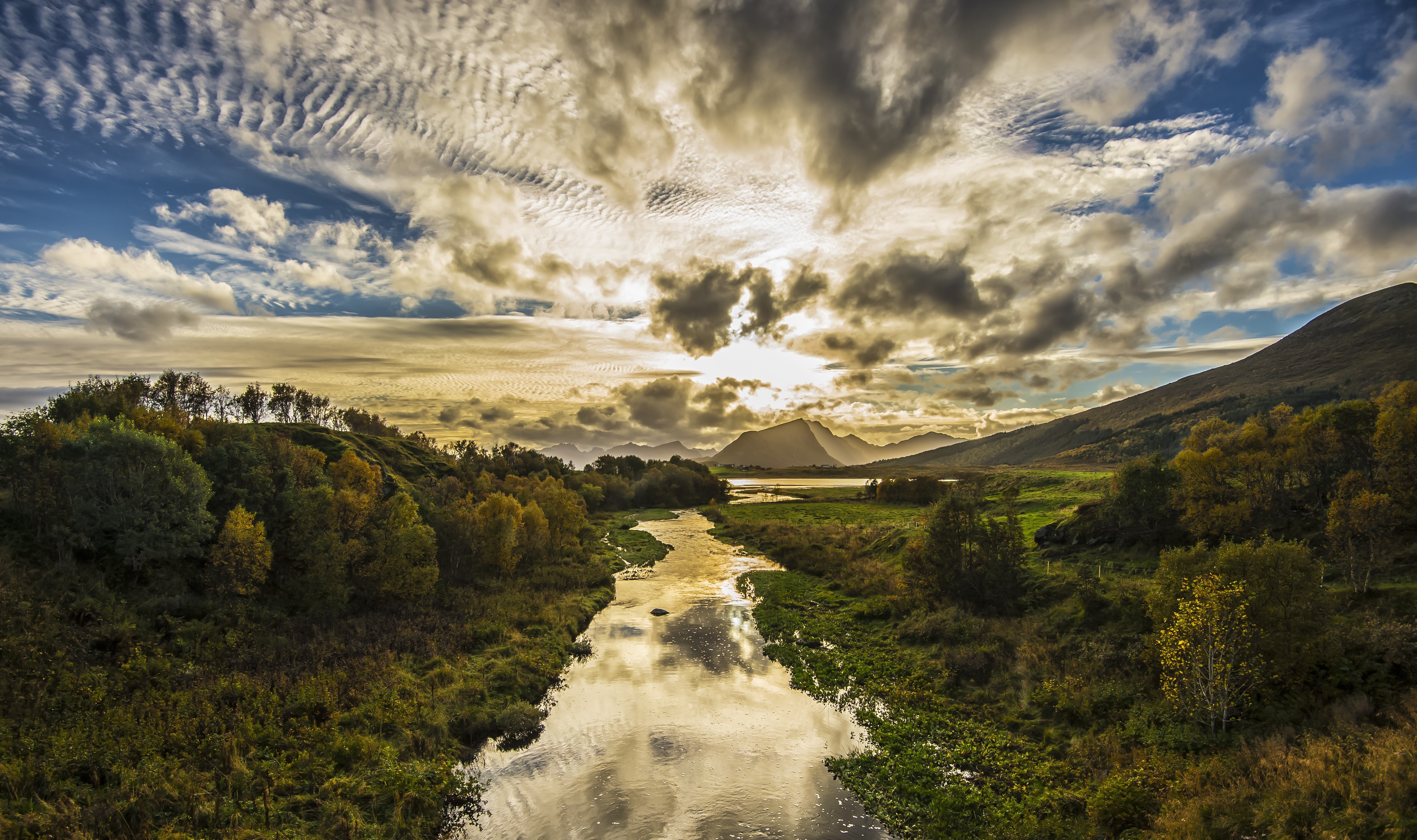 River flowing through a valley with mountains and clouds HD Wallpaper
