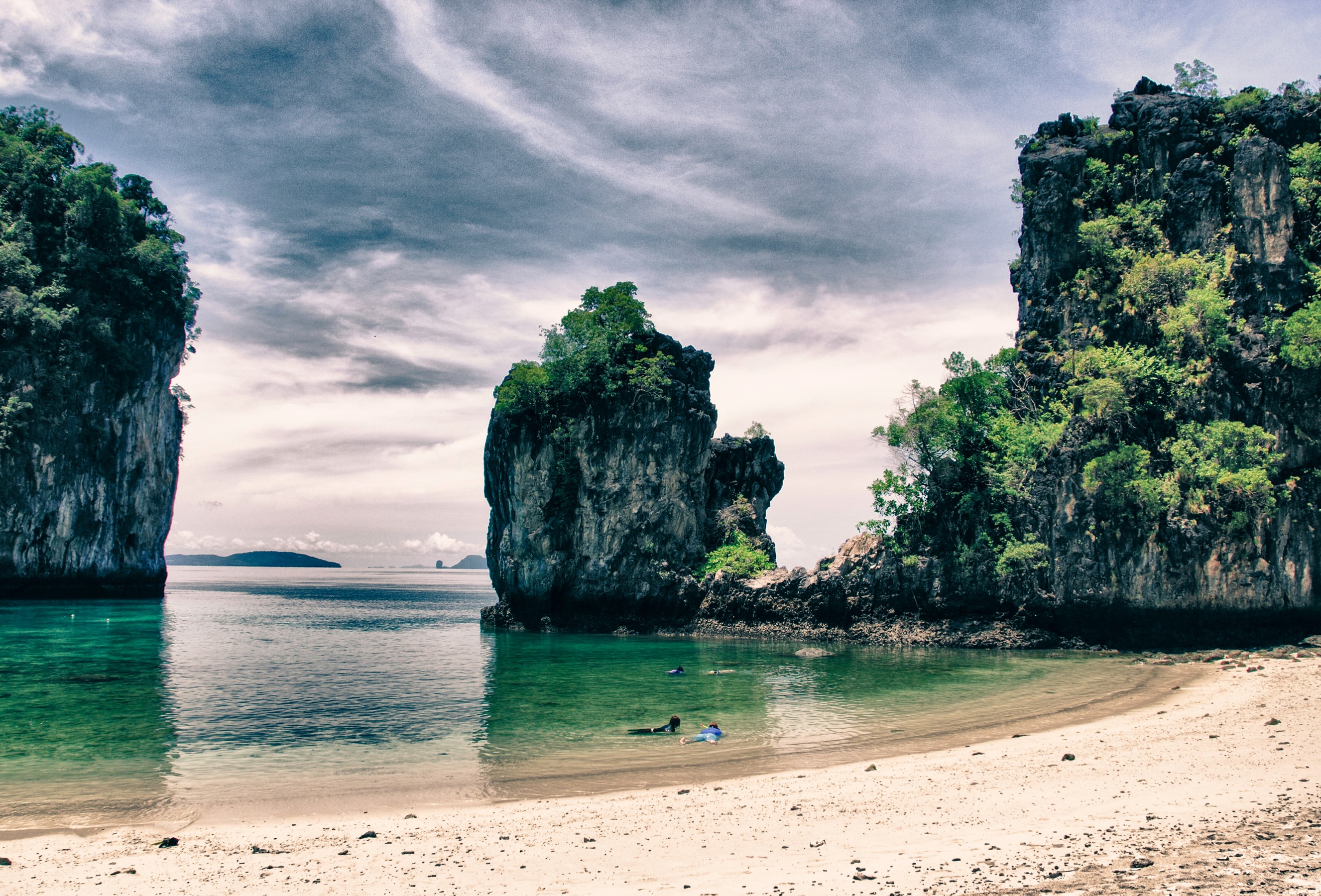 Thailand coast with limestone cliffs and snorkelers HD Wallpaper