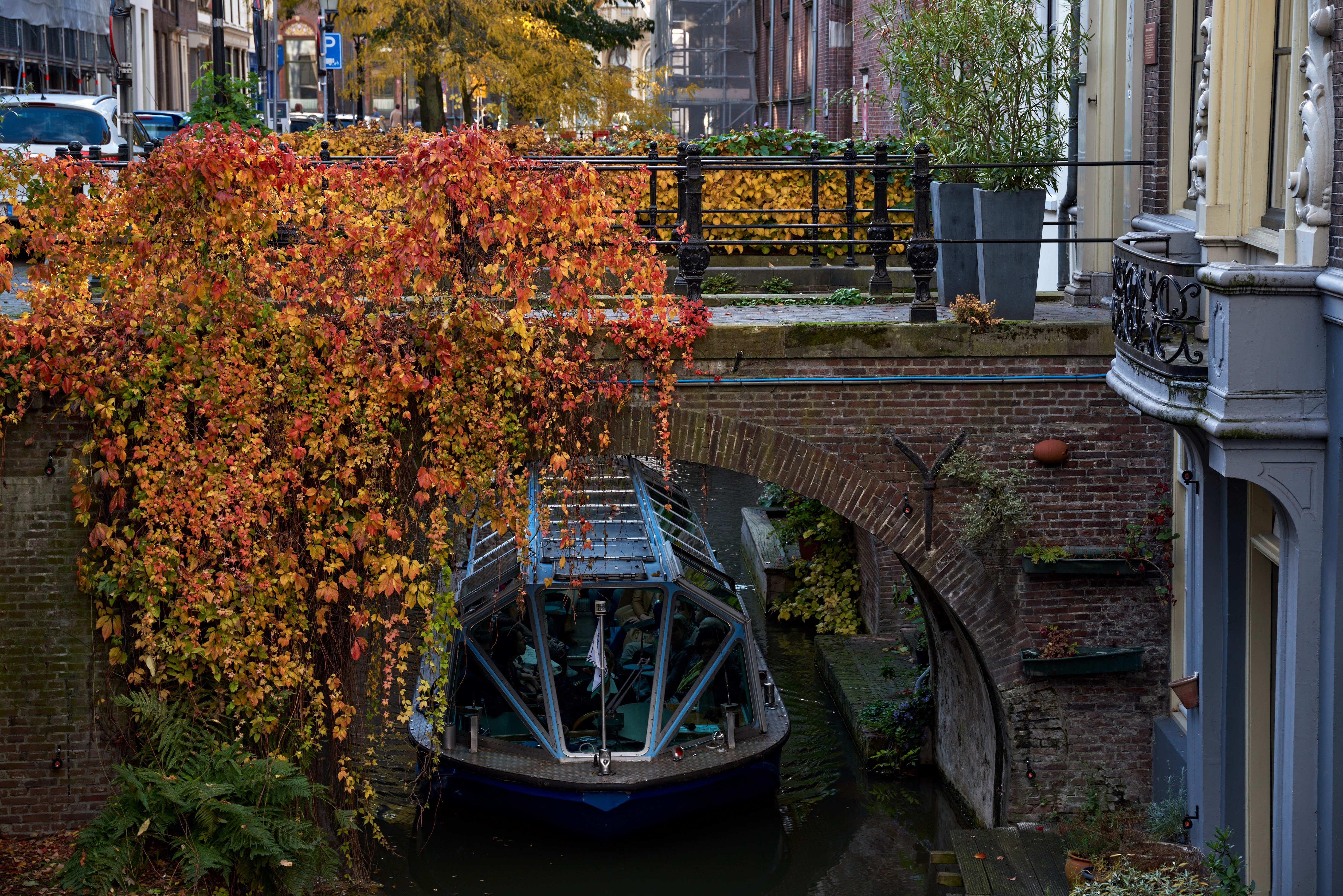 Riverboat passing under a bridge in Utrecht during Autumn HD Wallpaper