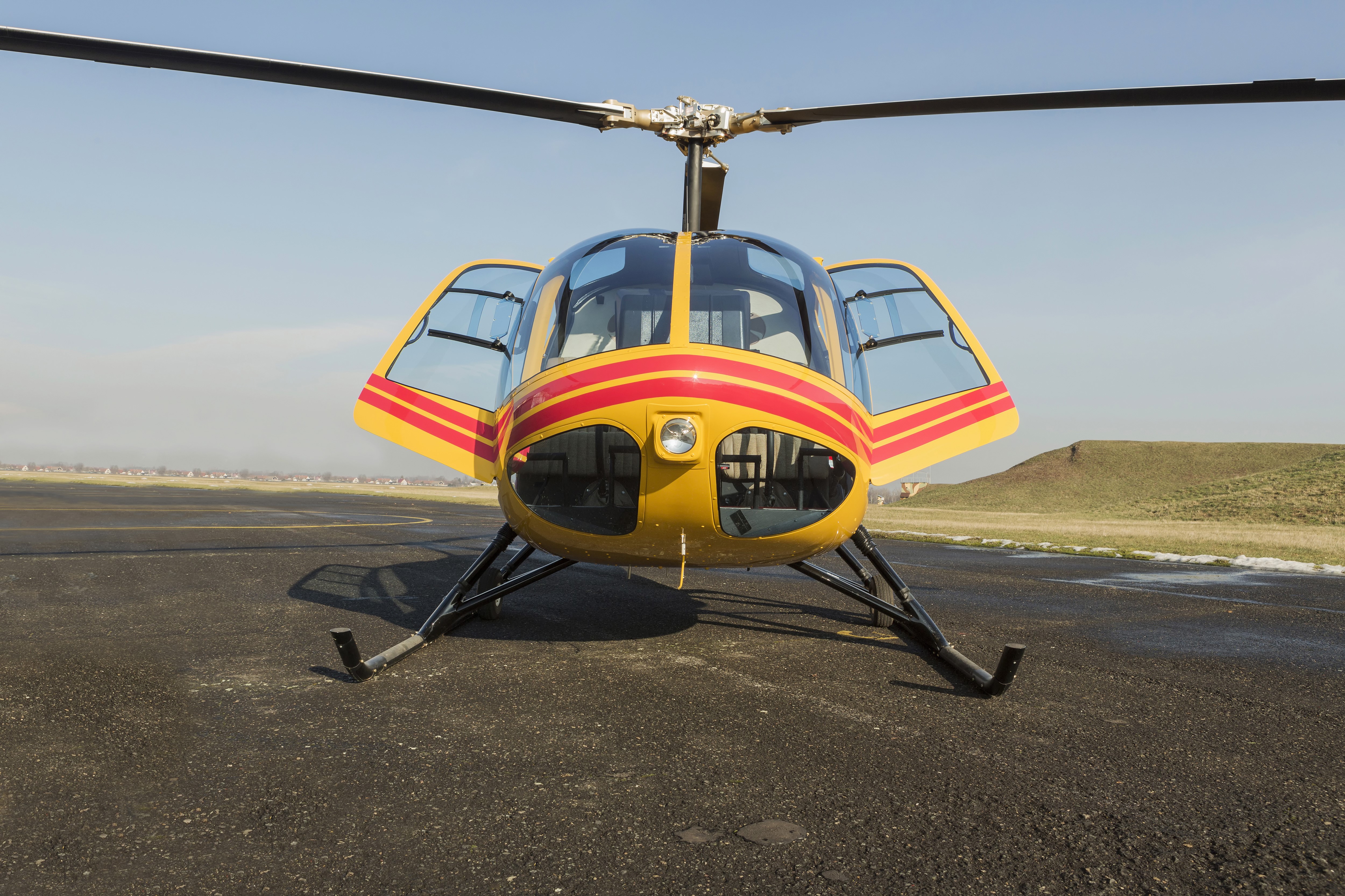 Yellow and red helicopter on tarmac HD Wallpaper