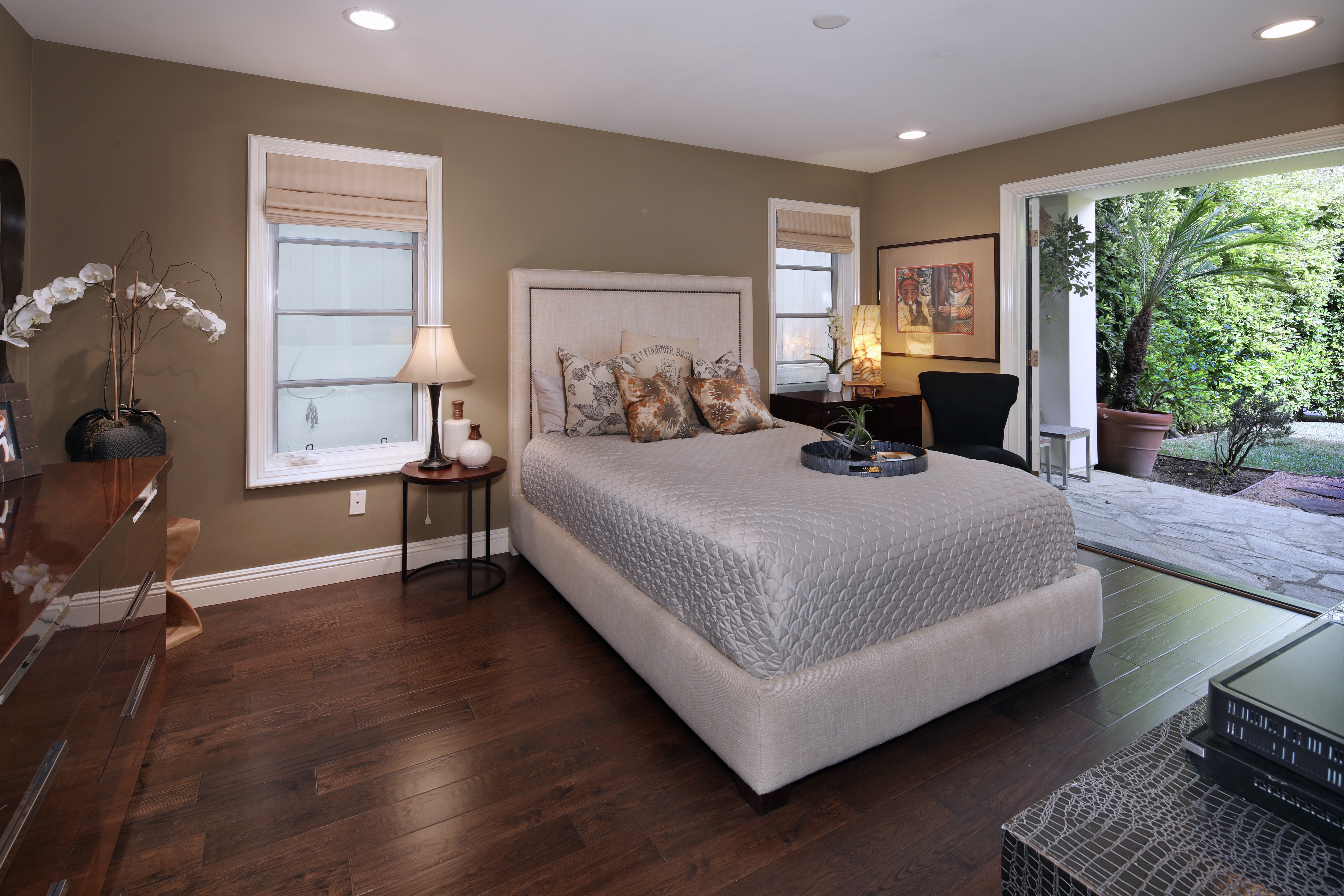 Bedroom with a bed, lamps, and a sliding glass door to a patio HD Wallpaper