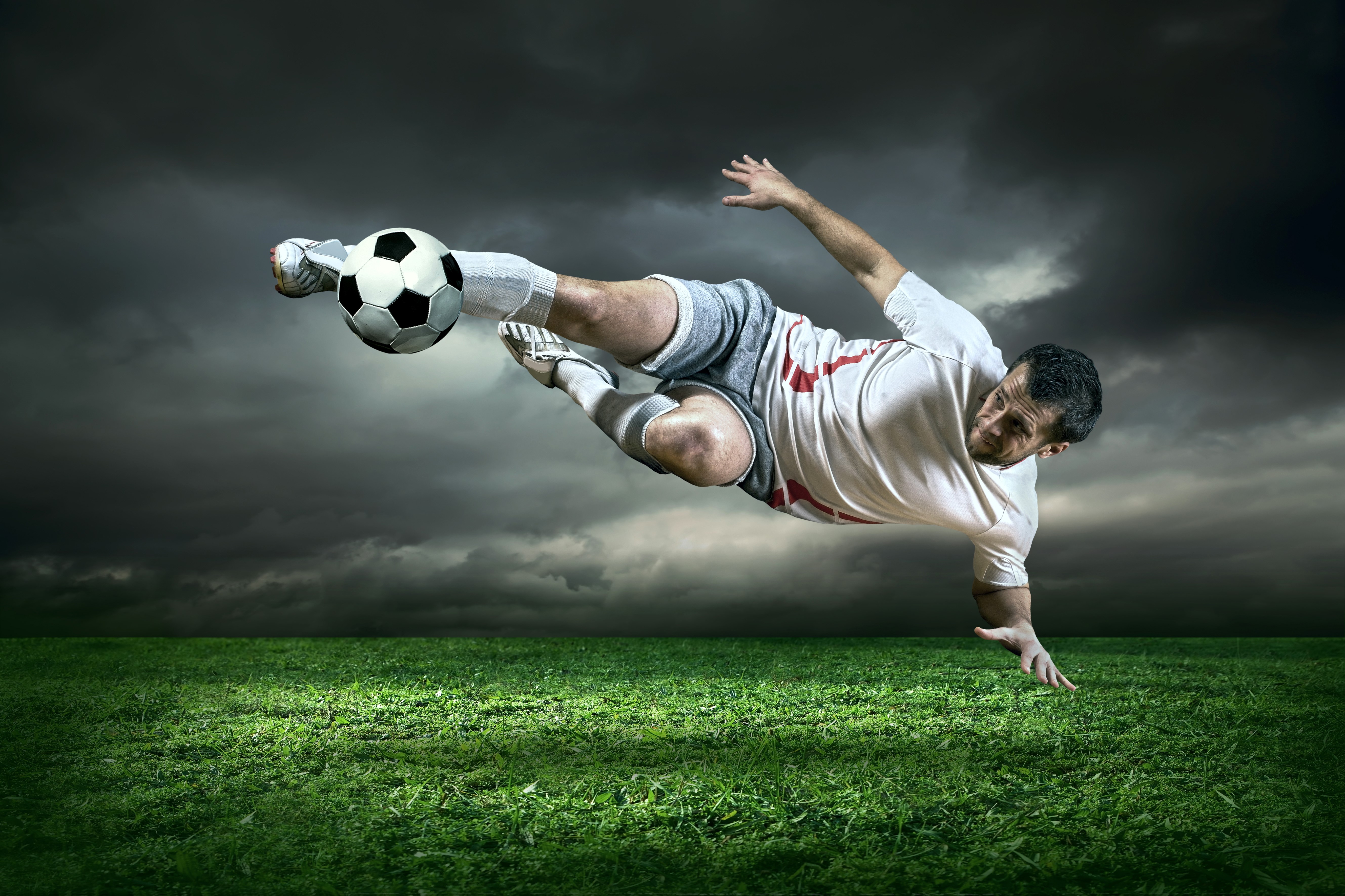 Man playing soccer on a grassy field HD Wallpaper