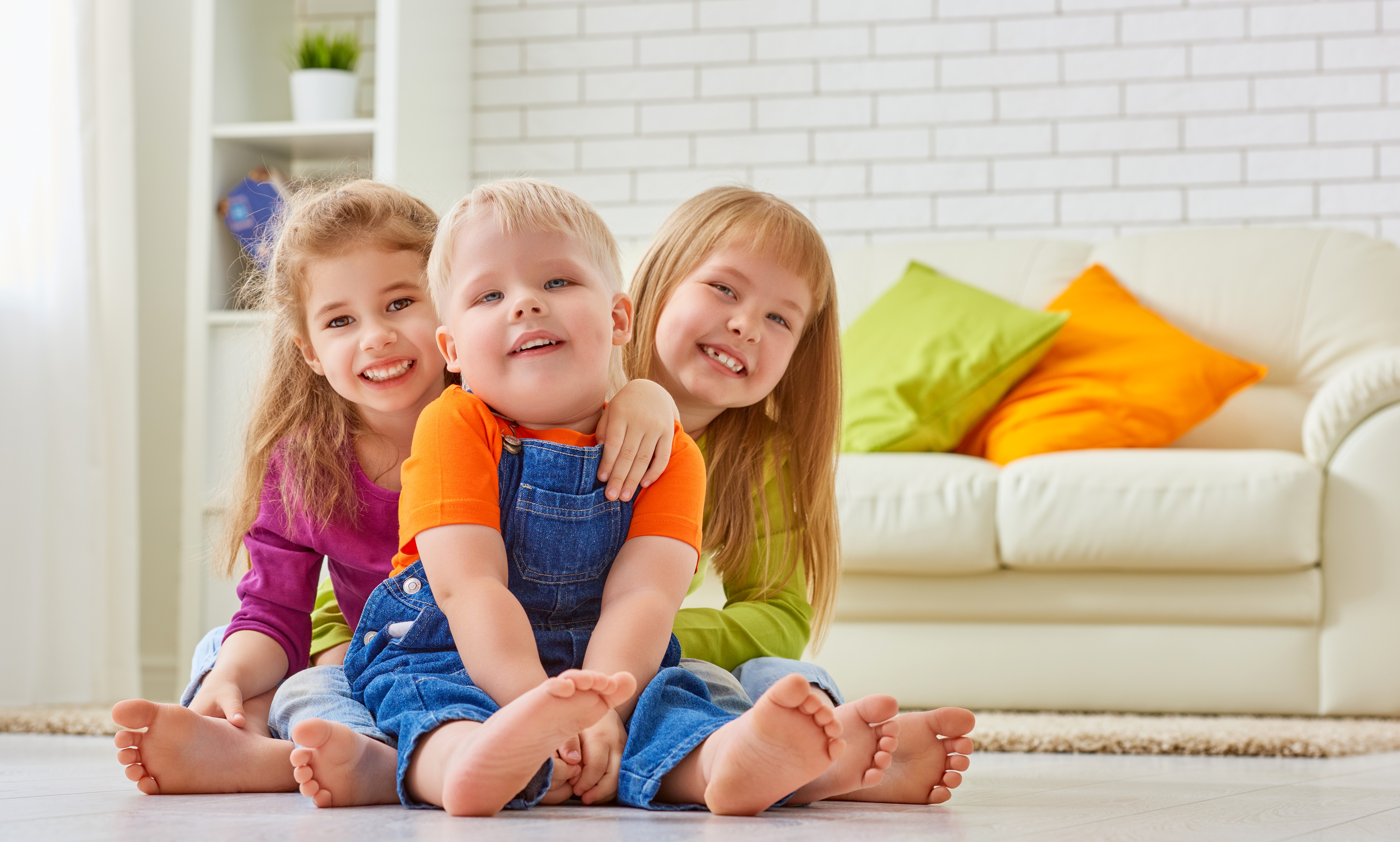 Three children smiling and sitting on the floor HD Wallpaper