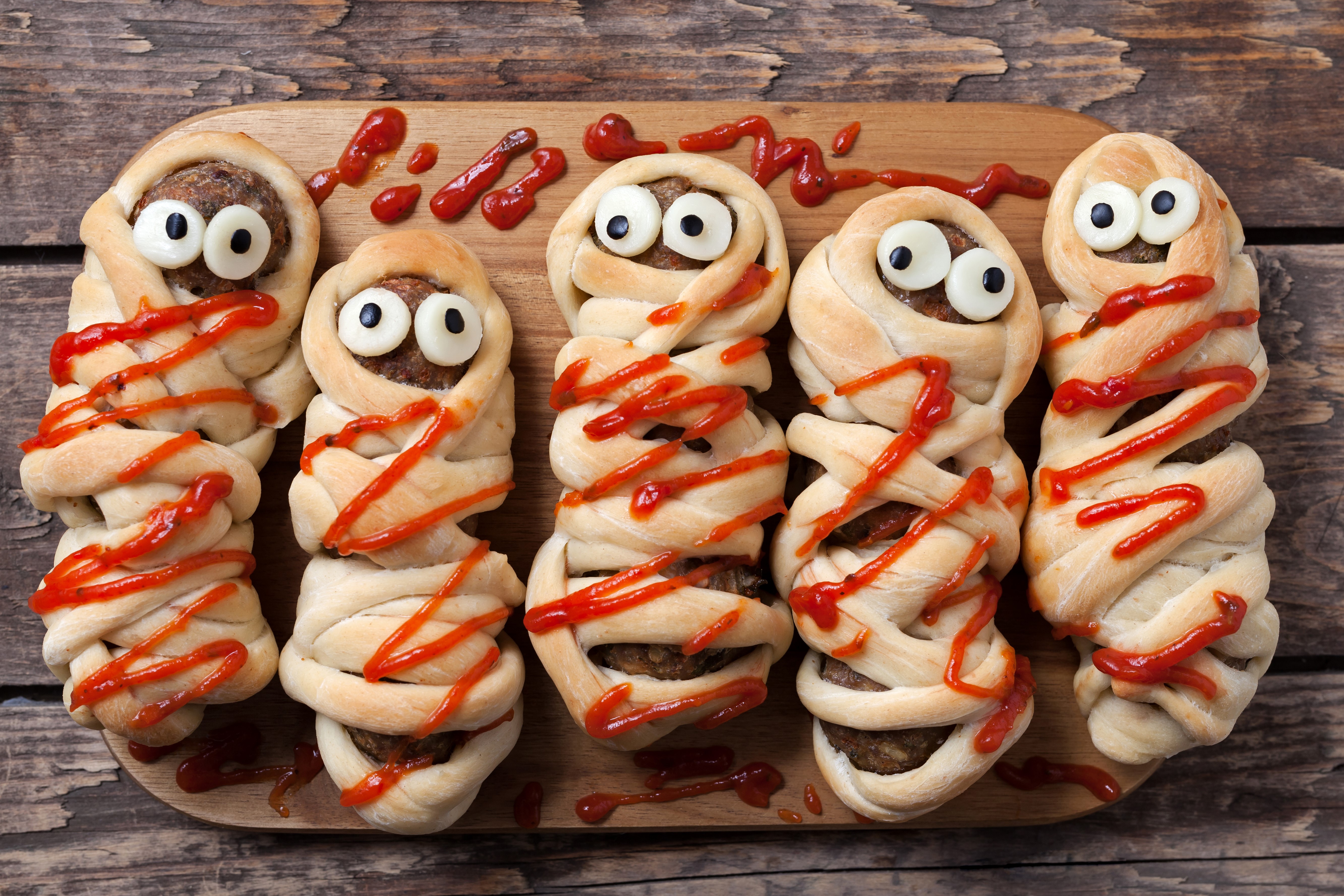 Mummy meatloaf with ketchup on a cutting board HD Wallpaper
