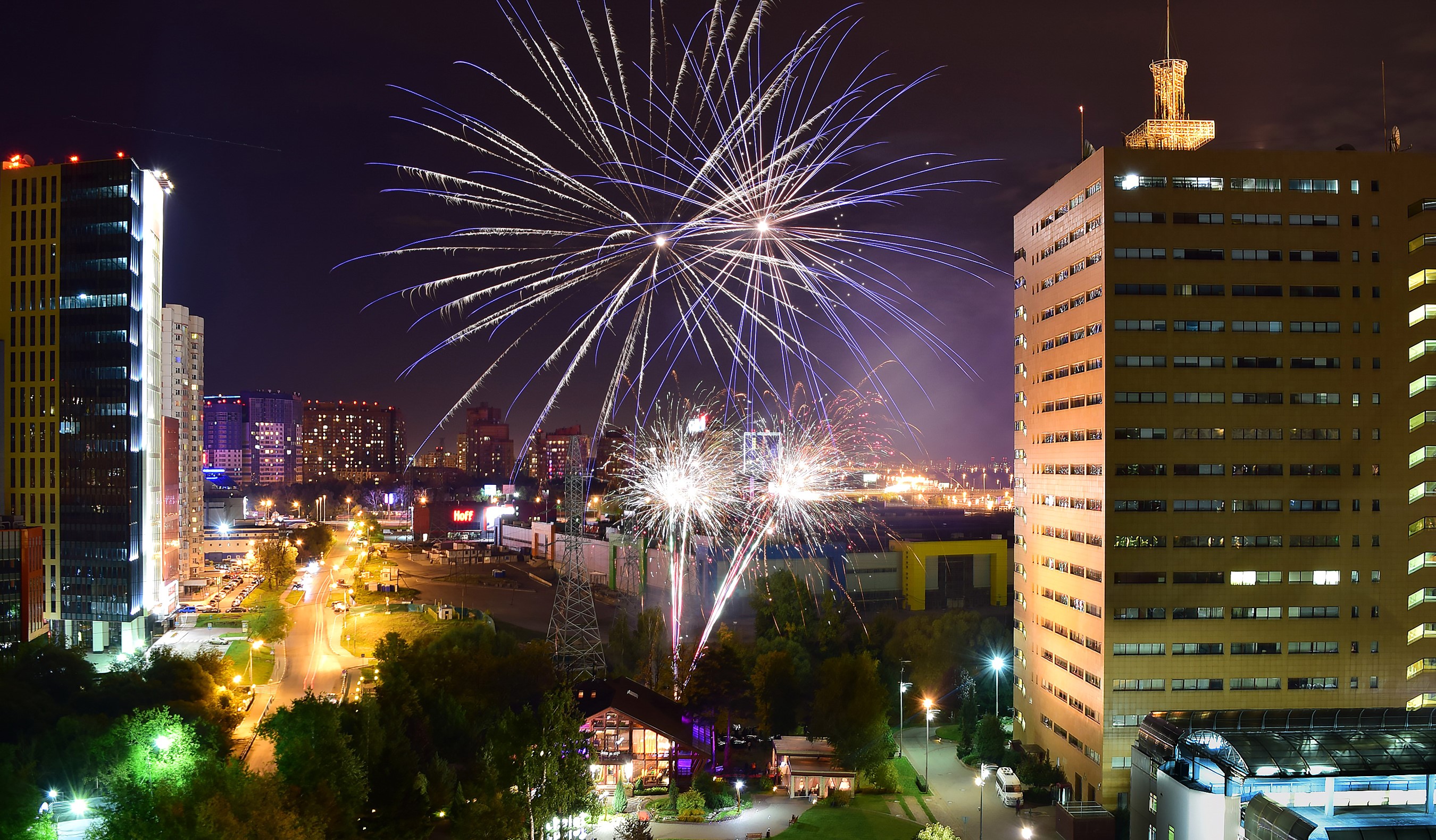 Fireworks over city buildings at night HD Wallpaper