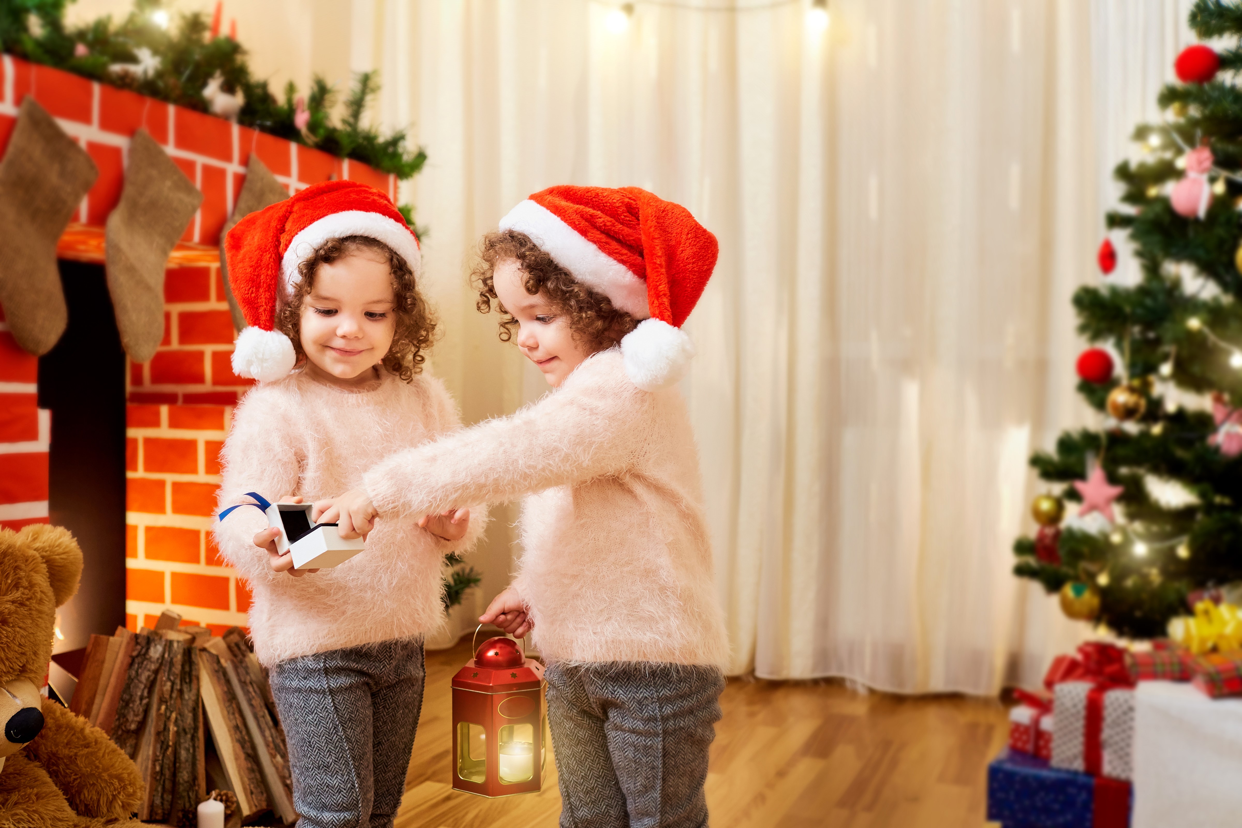 Two little girls in Santa hats with Christmas gifts HD Wallpaper