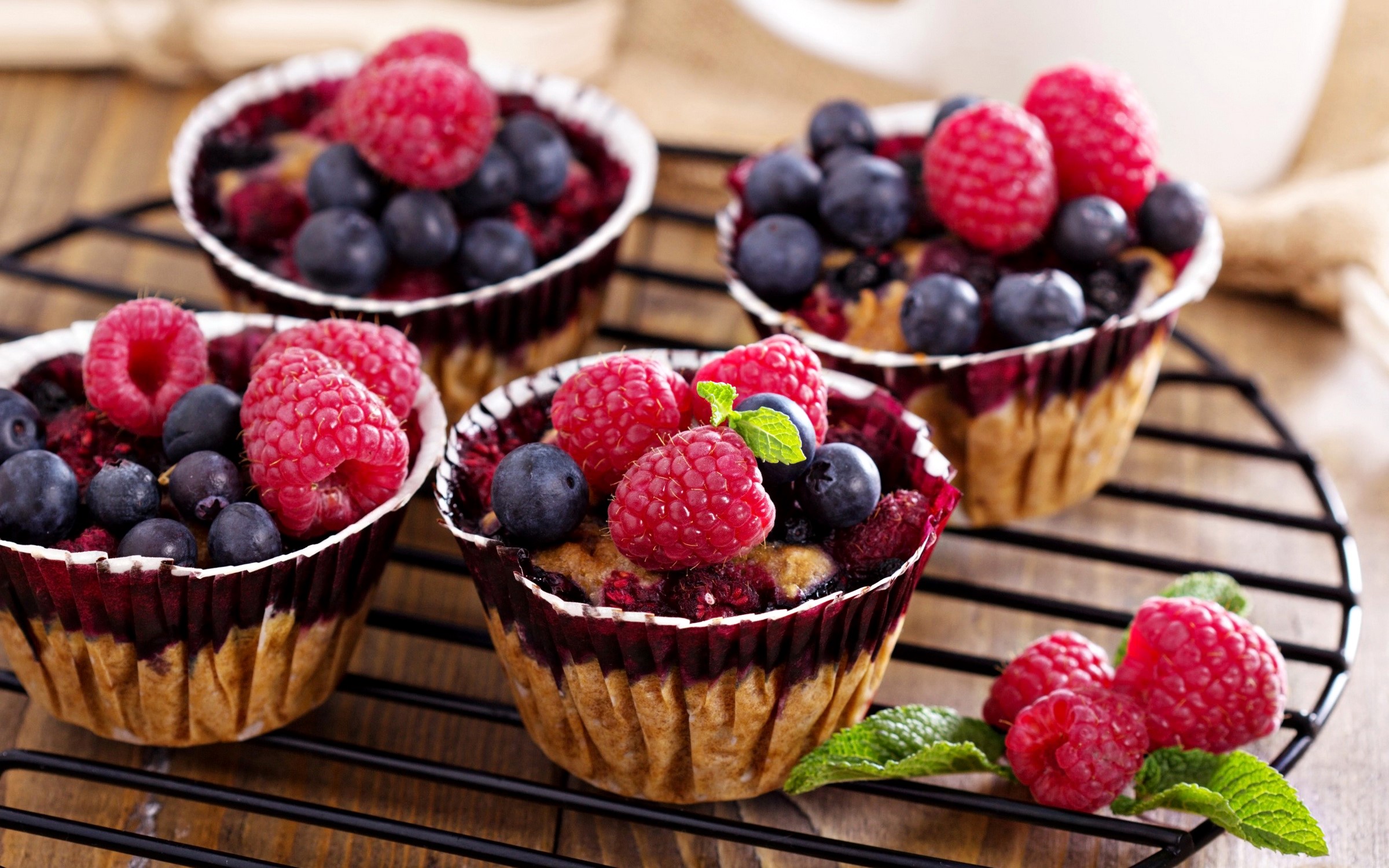Berry muffins with raspberries and blueberries on a cooling rack HD Wallpaper