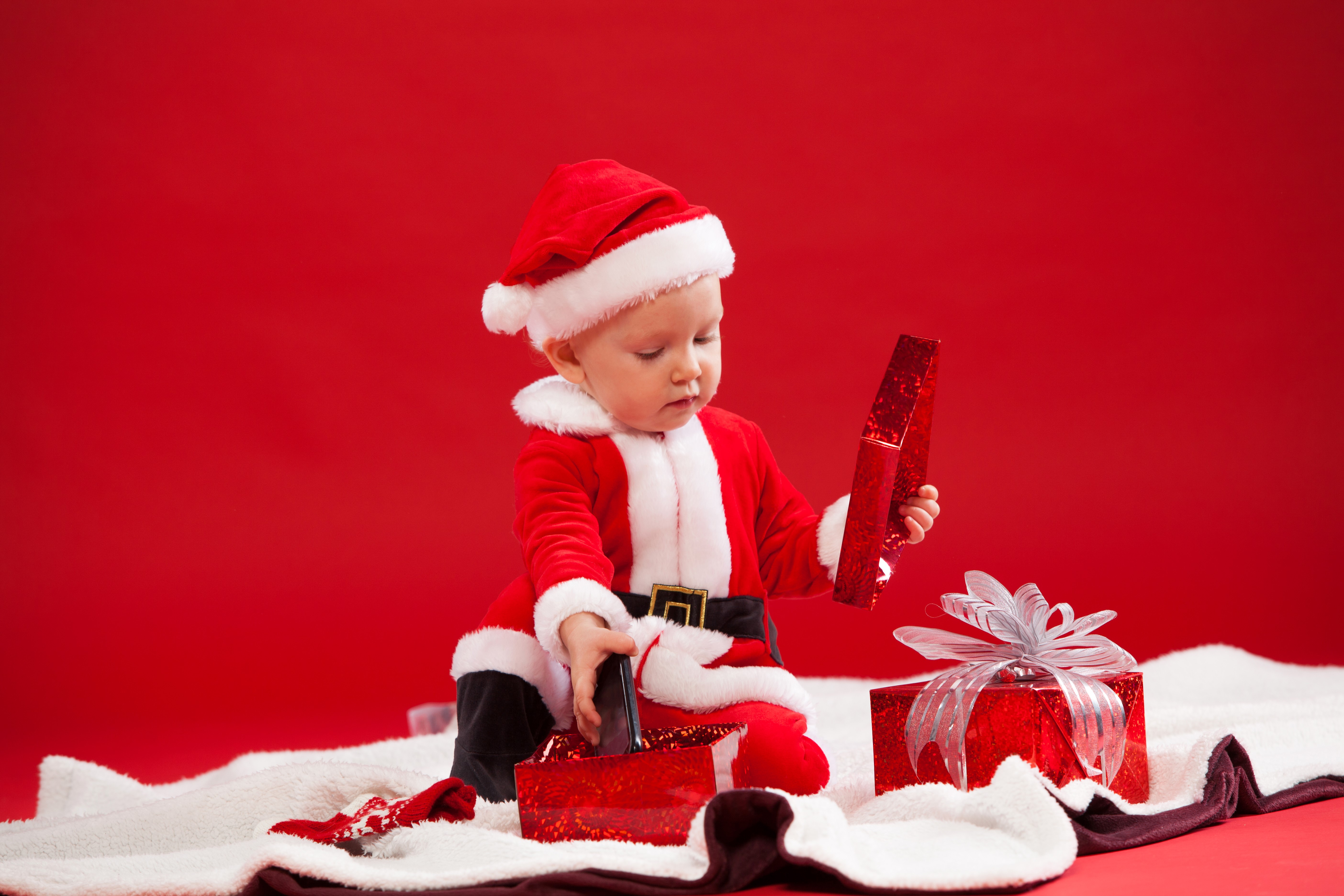 Baby in Santa Claus uniform opening gifts HD Wallpaper