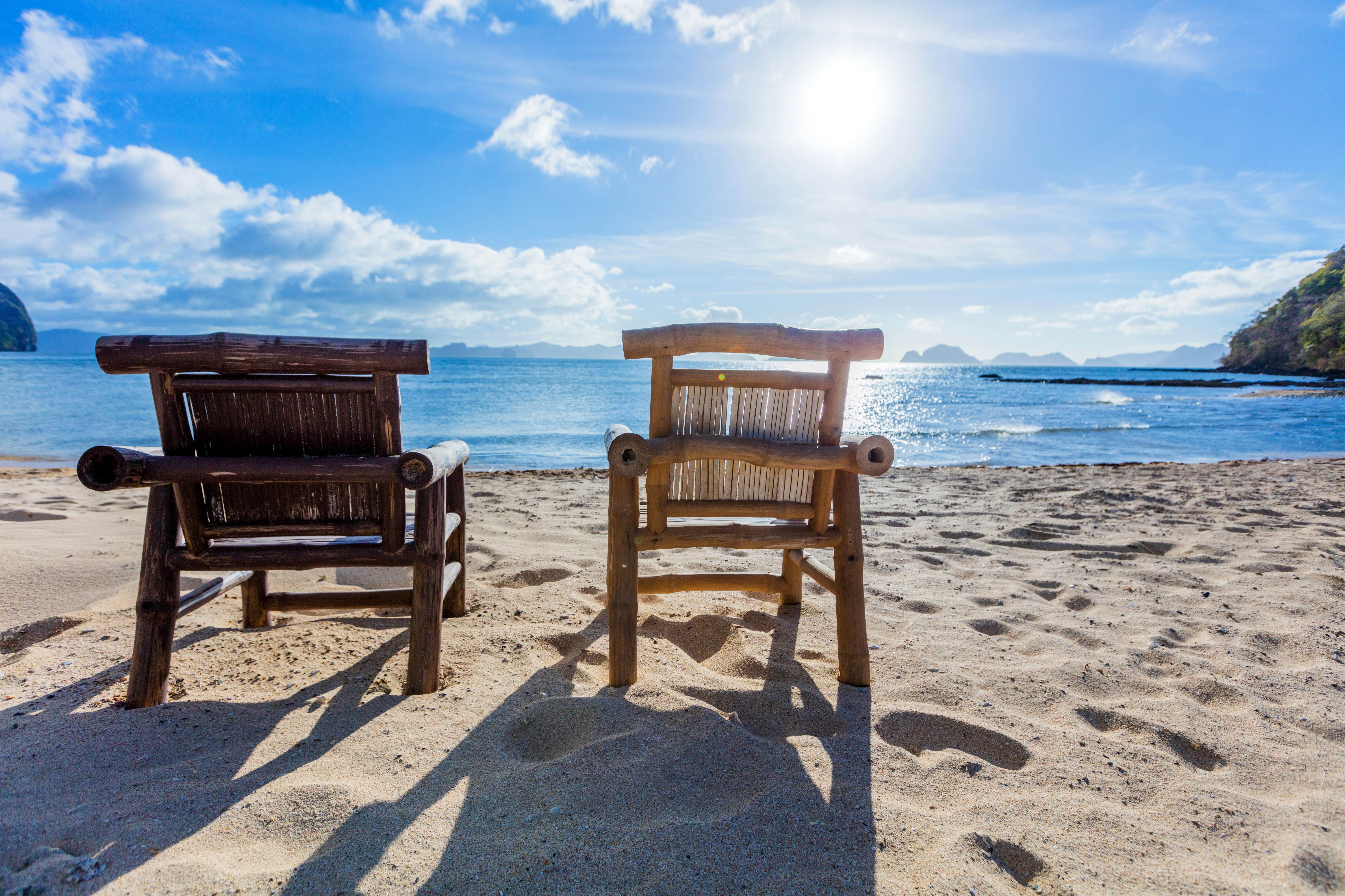 Two bamboo chairs on a tropical beach in the Philippines HD Wallpaper