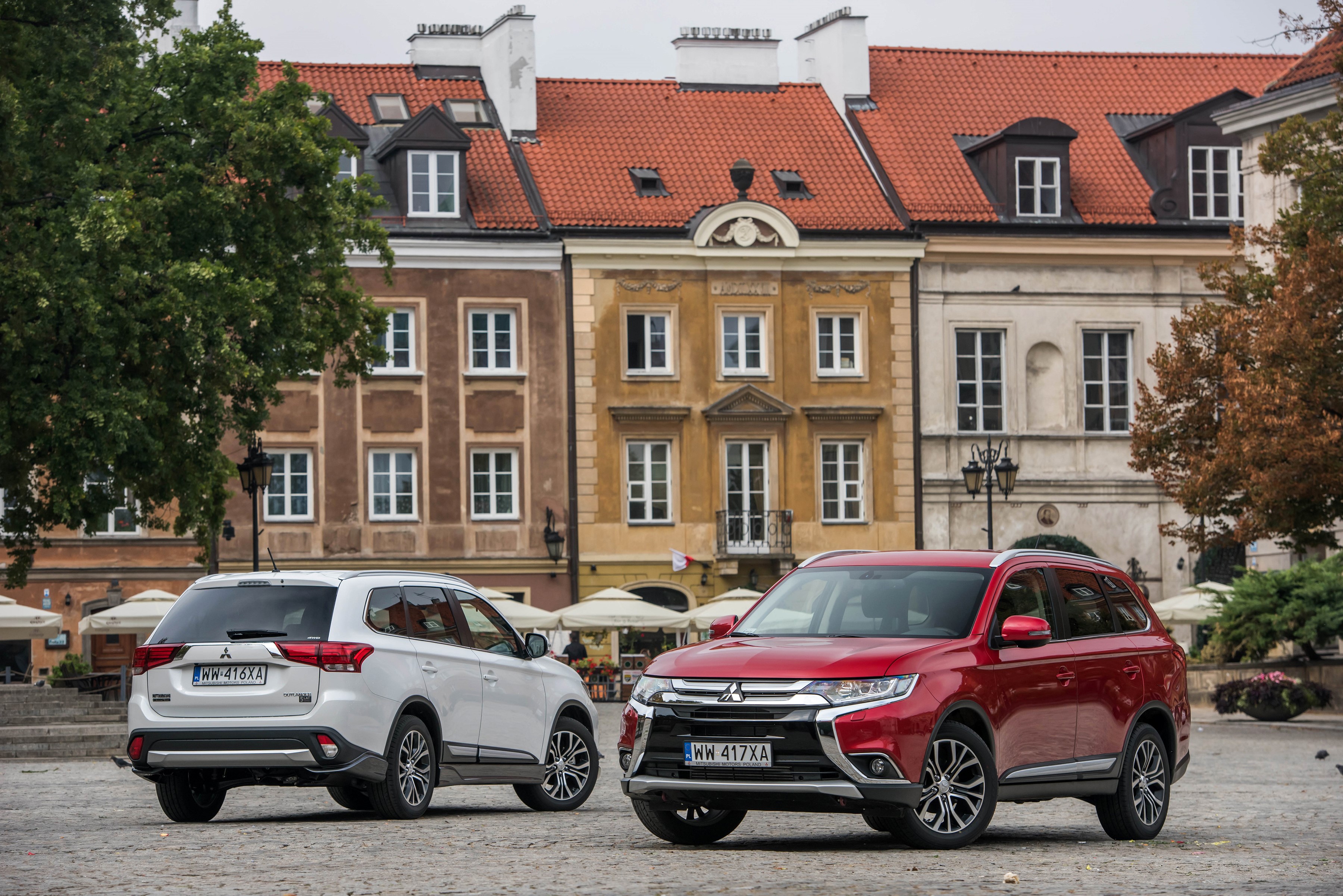 Two Mitsubishi Outlanders parked in a European city square HD Wallpaper