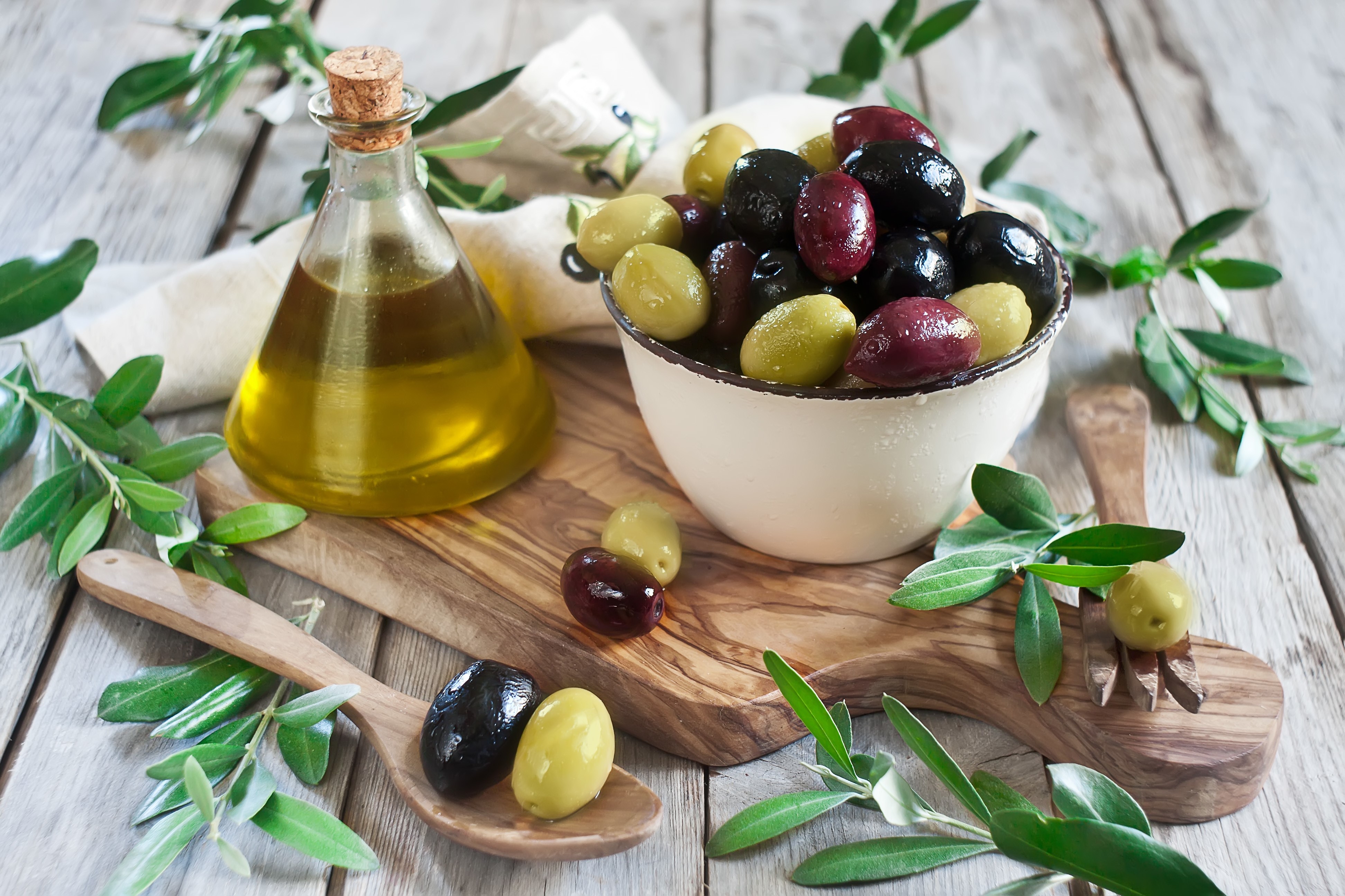 Olives and olive oil on a wooden board HD Wallpaper