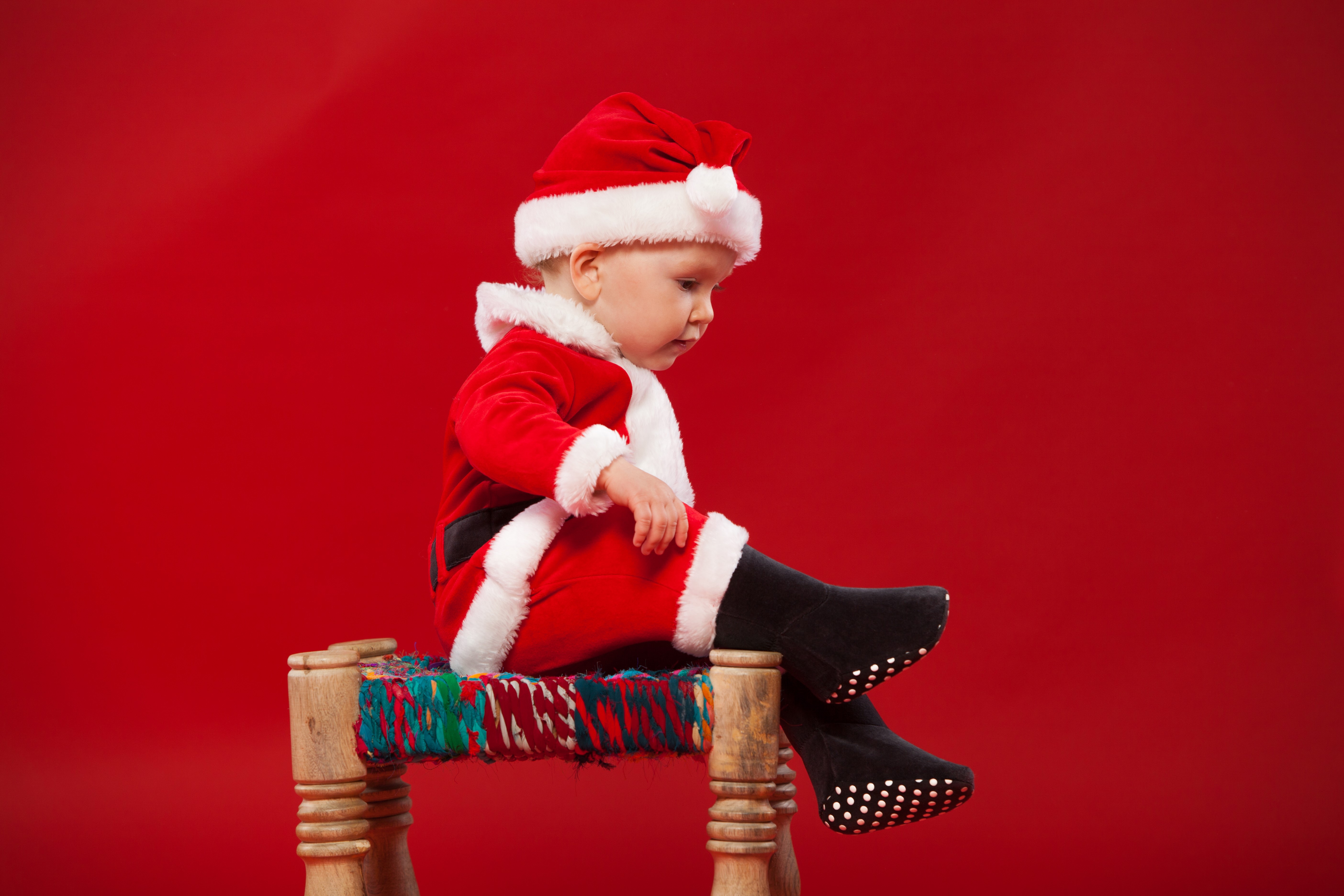 Baby in Santa Claus uniform on red background HD Wallpaper