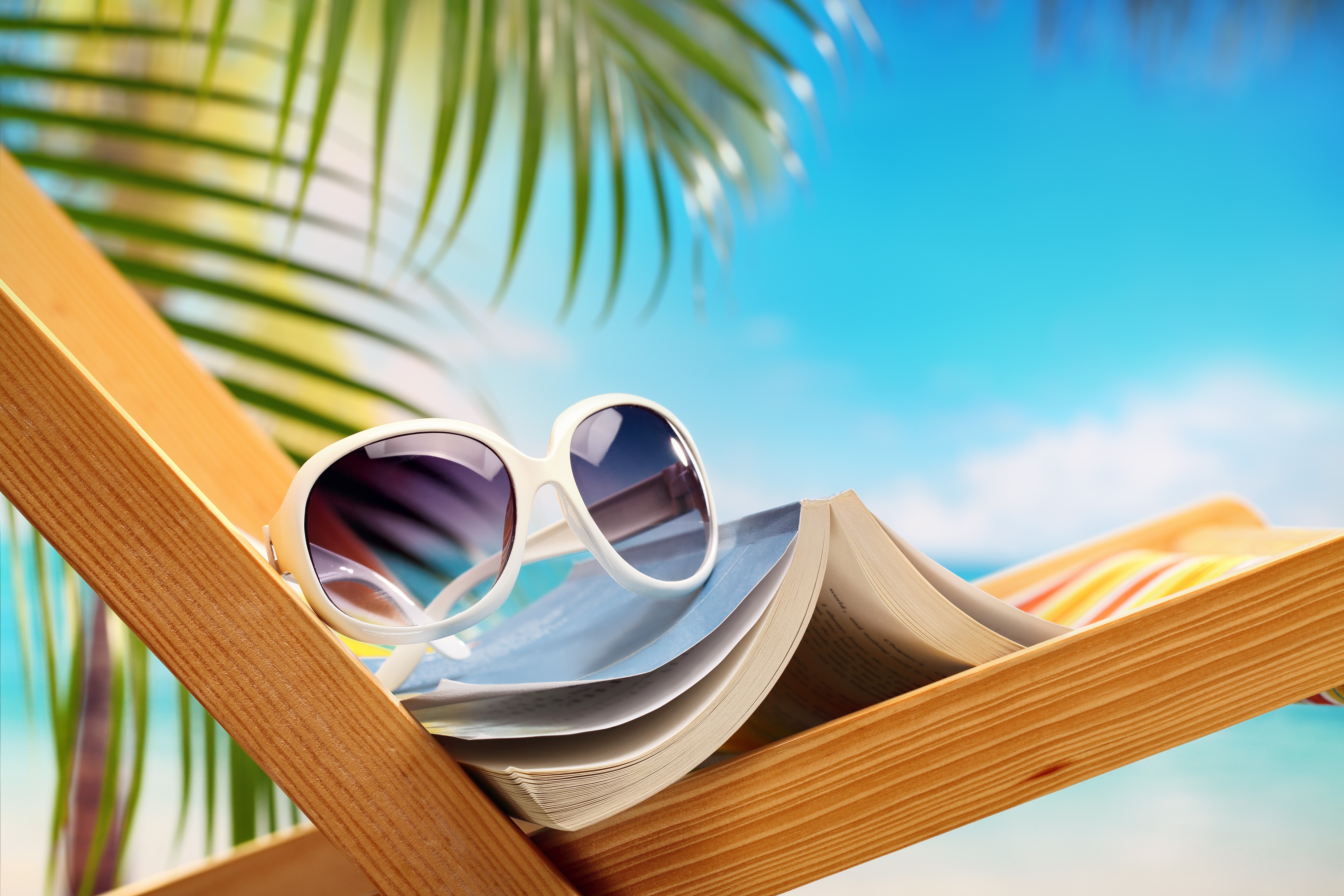 Sunglasses on a book on a beach chair HD Wallpaper