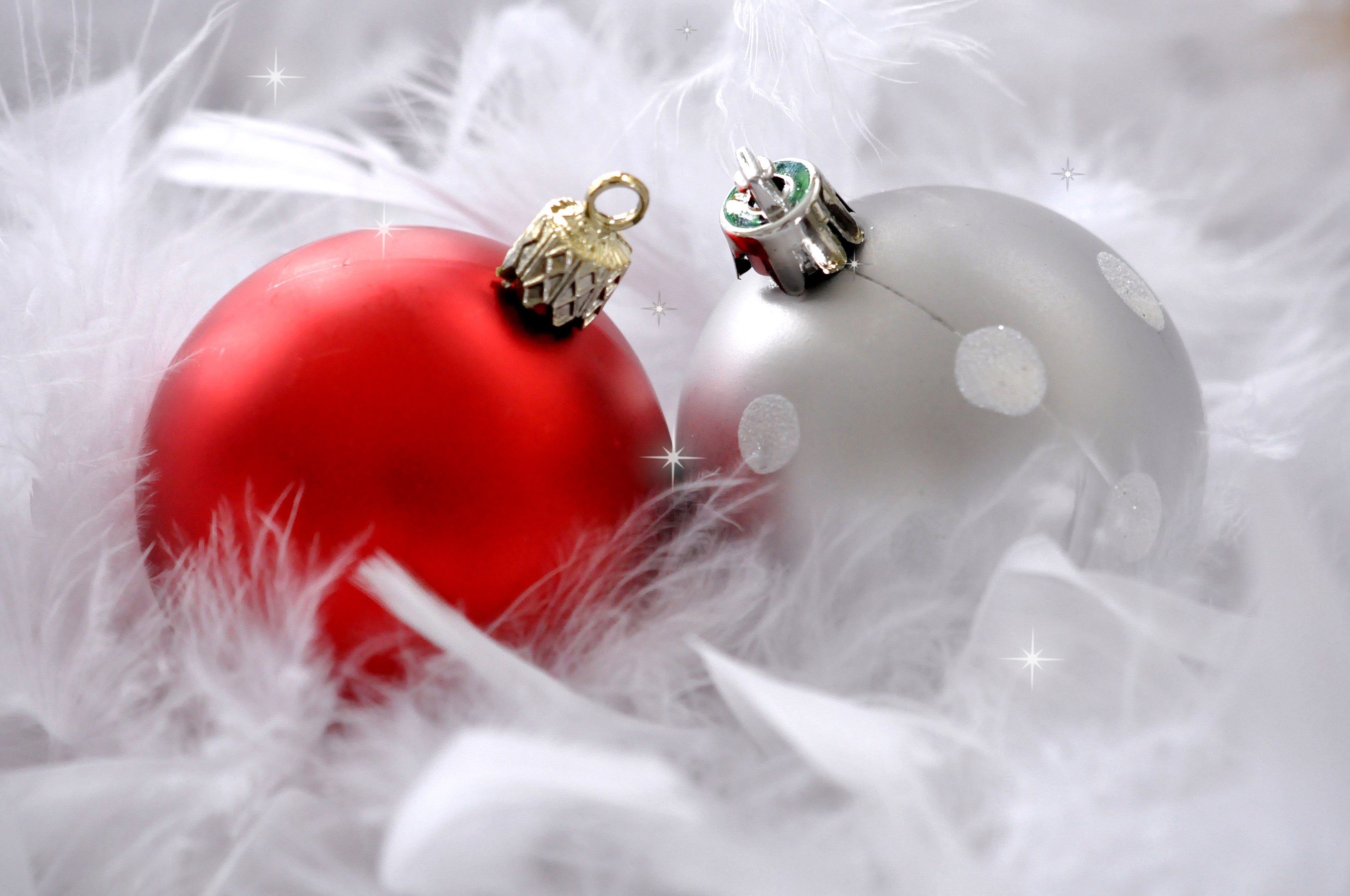 Two Christmas ornaments on white feathers HD Wallpaper
