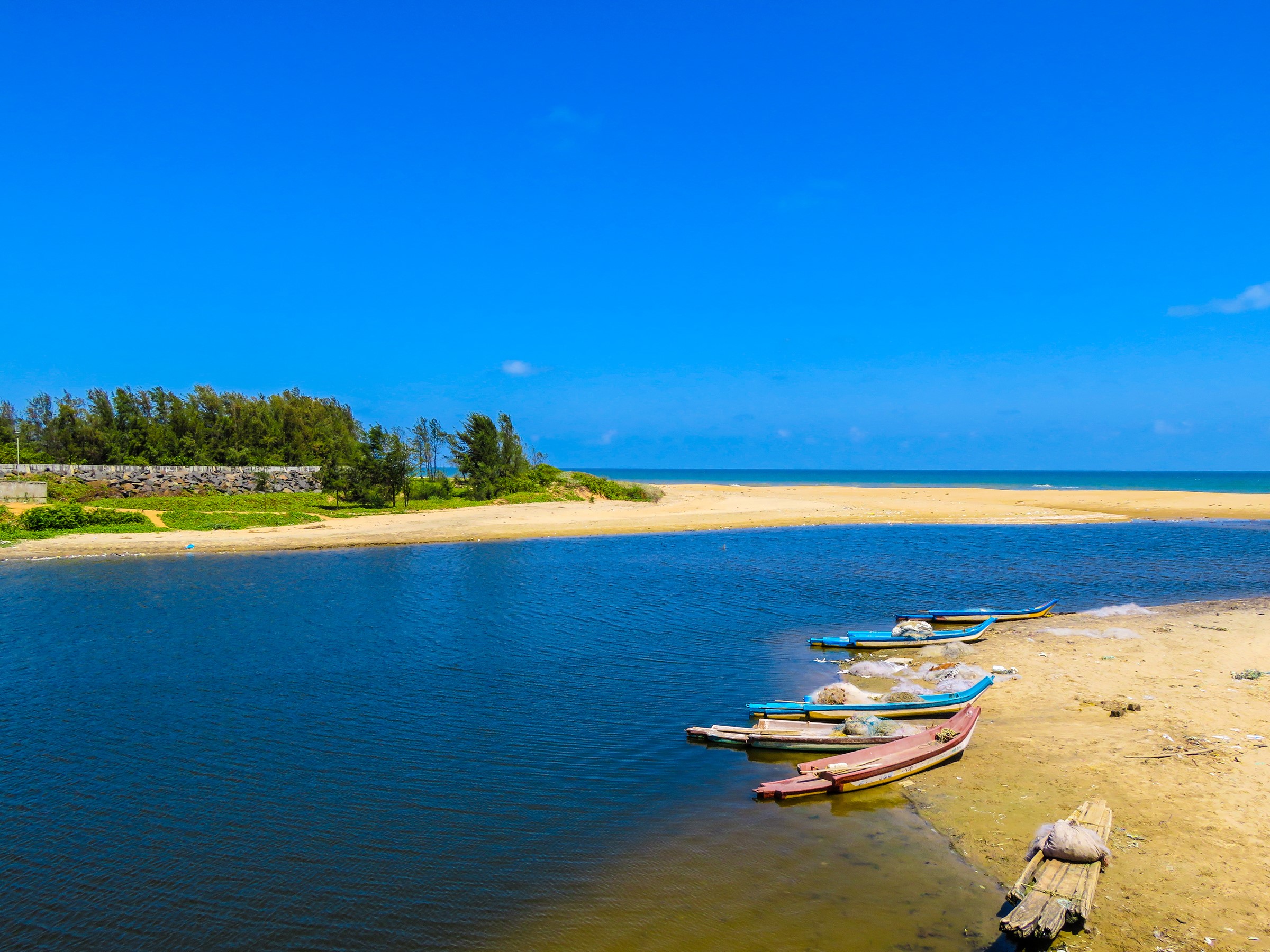 Boats on a sandy beach with a blue sky and ocean HD Wallpaper