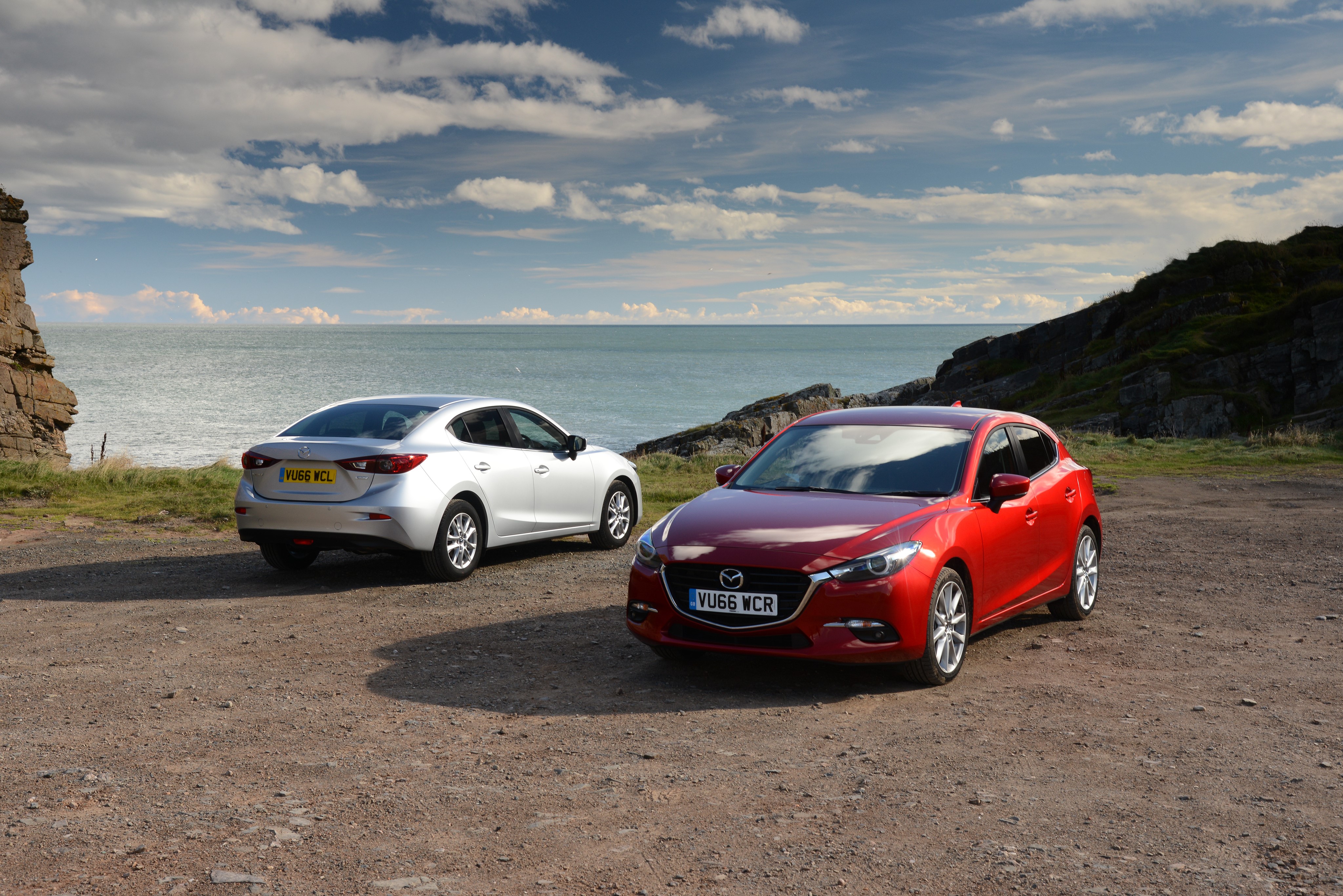 Two Mazda 3 cars by the sea HD Wallpaper