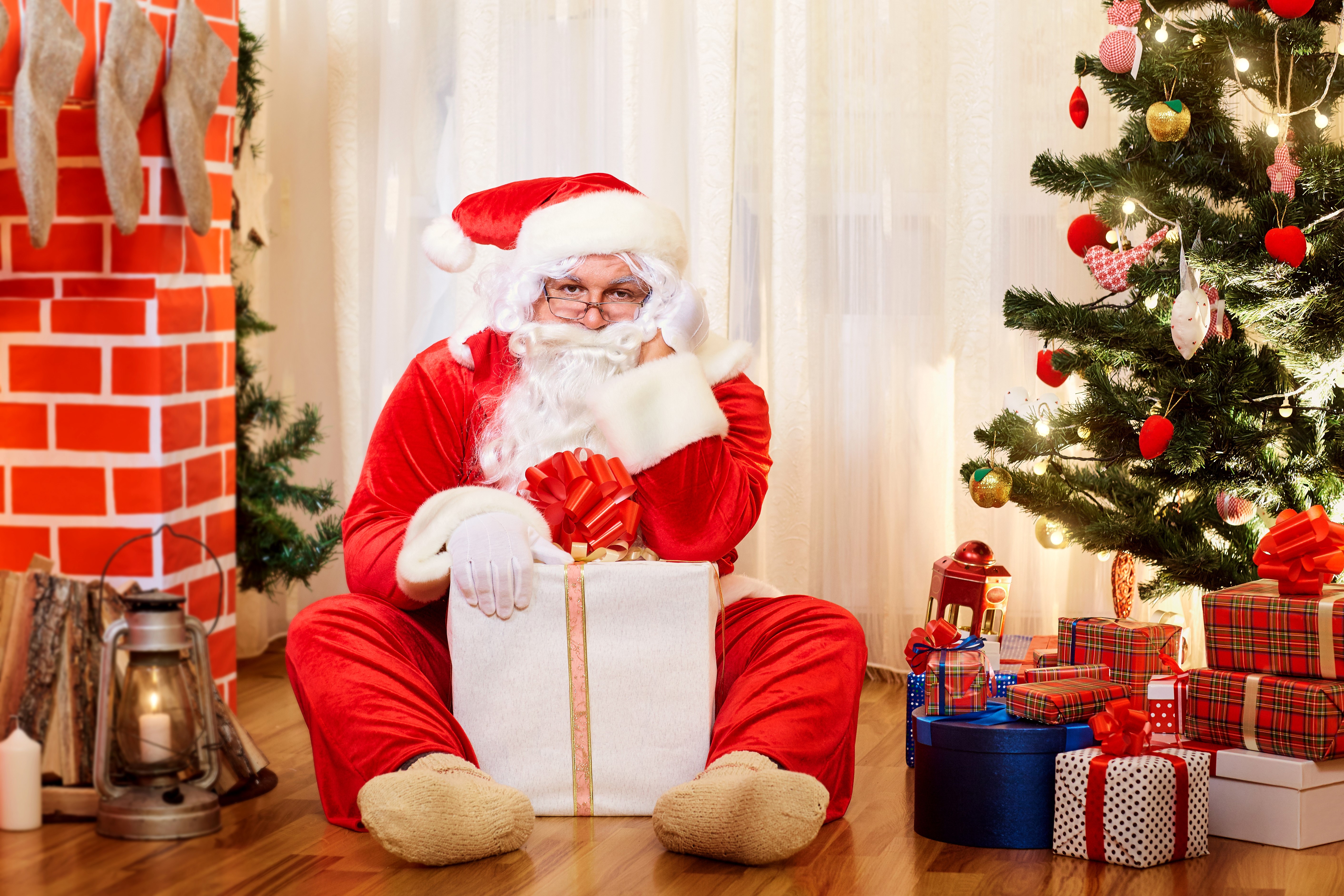 Santa Claus with Gifts by Christmas Tree and Fireplace HD Wallpaper