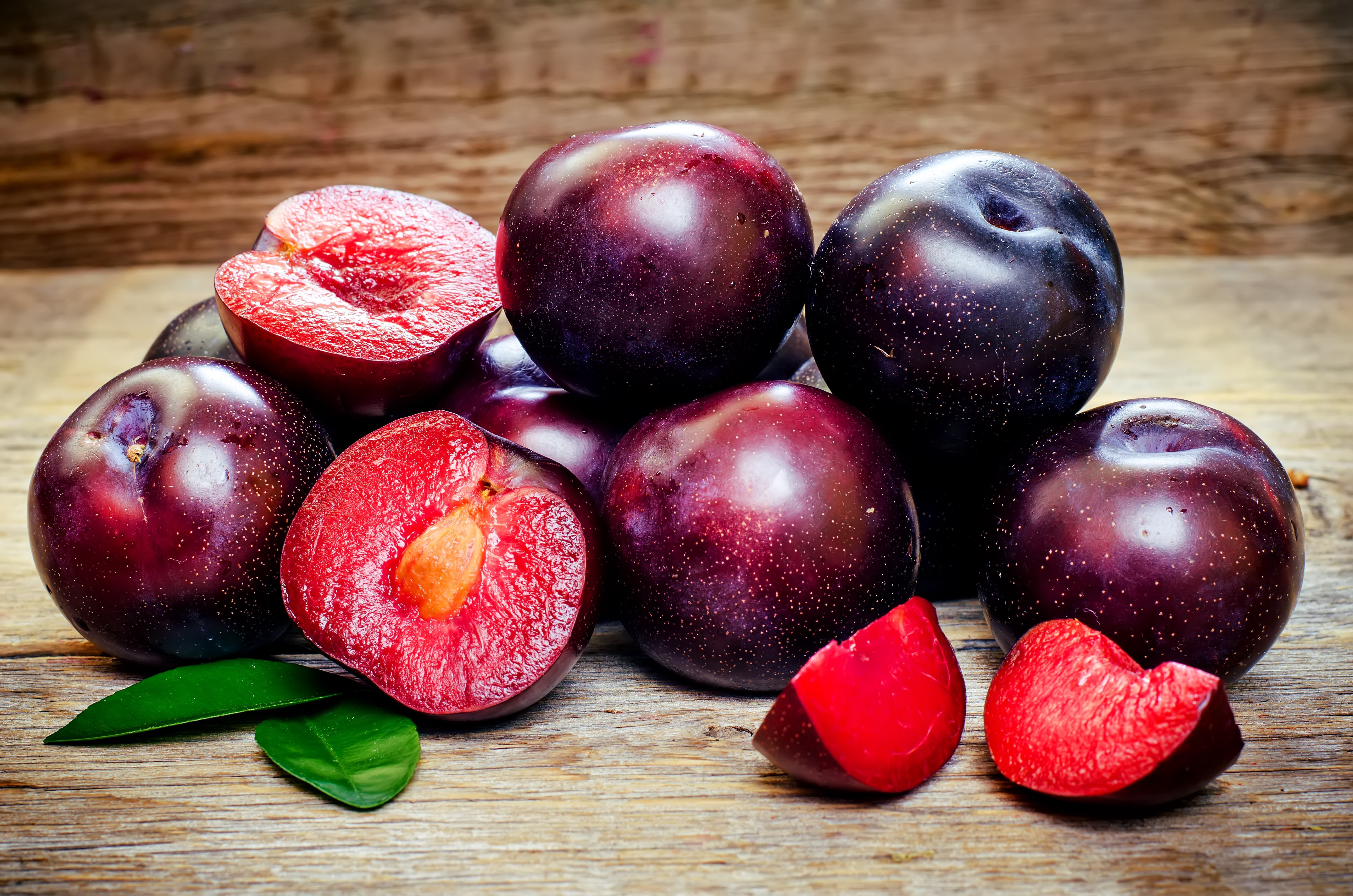 Plums on a wooden surface HD Wallpaper