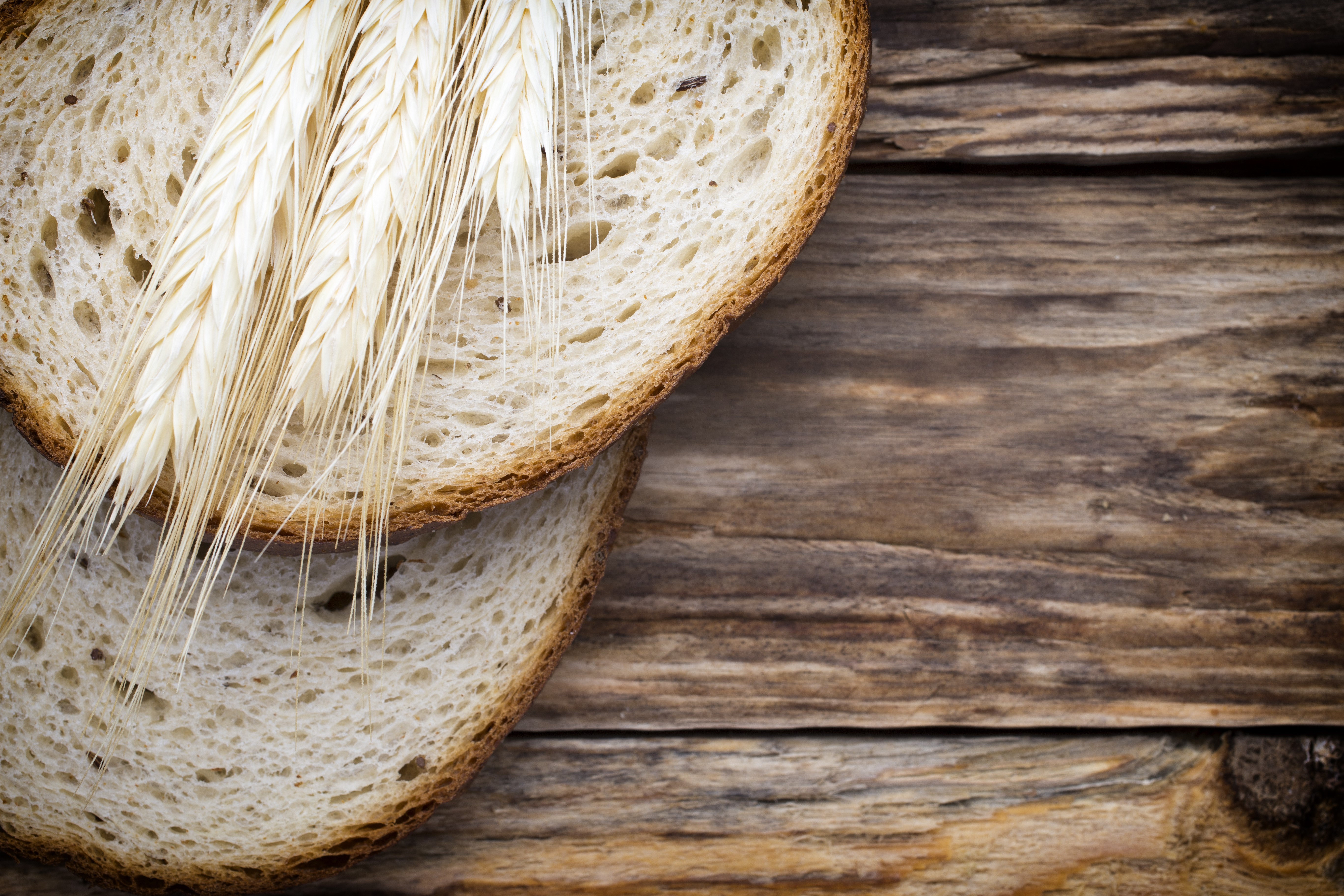 Slices of bread with wheat ears on wooden background HD Wallpaper