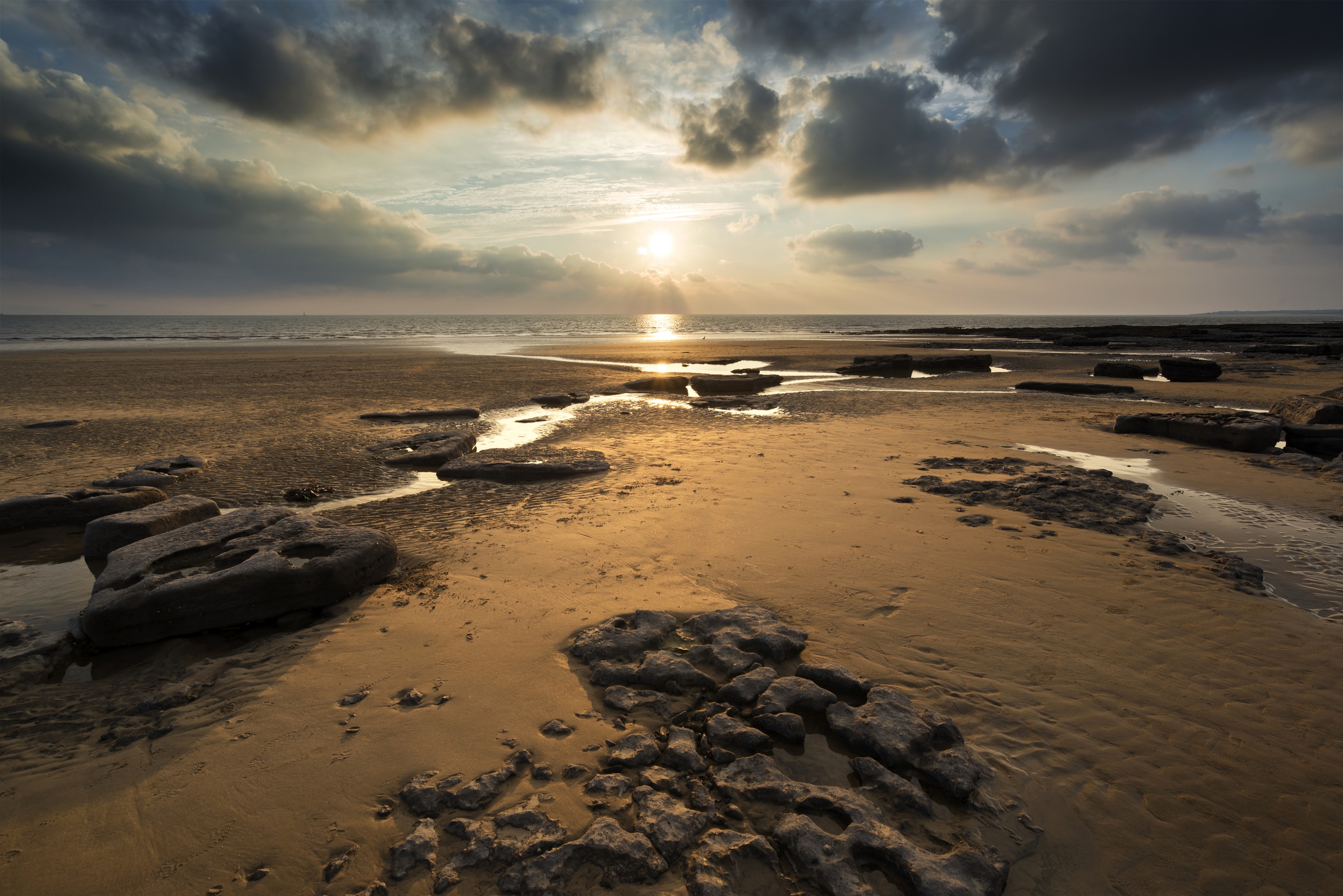 Sunset over Dunraven Bay, Wales with rocks and sand HD Wallpaper