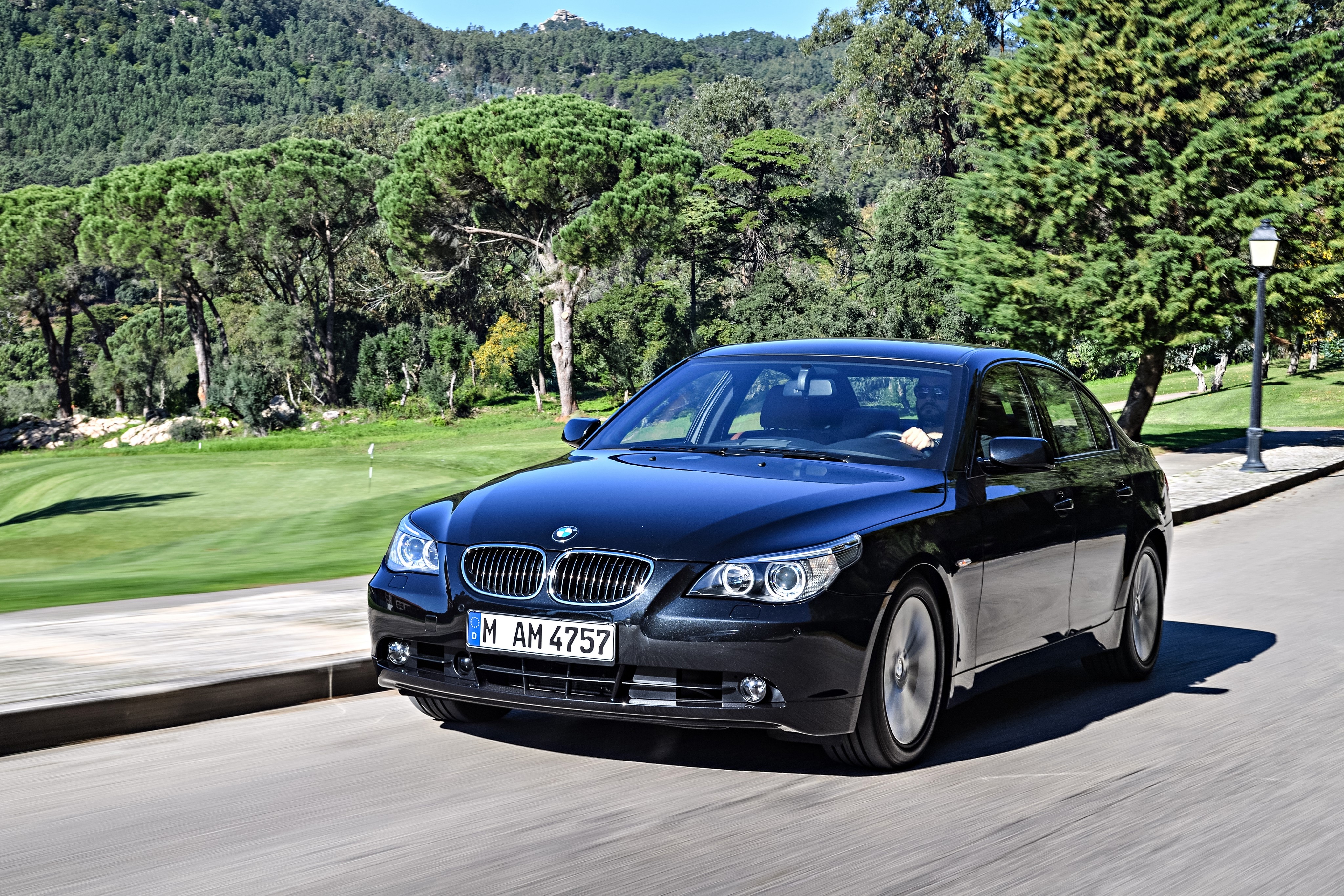 Black BMW 545i Sedan driving on a road HD Wallpaper