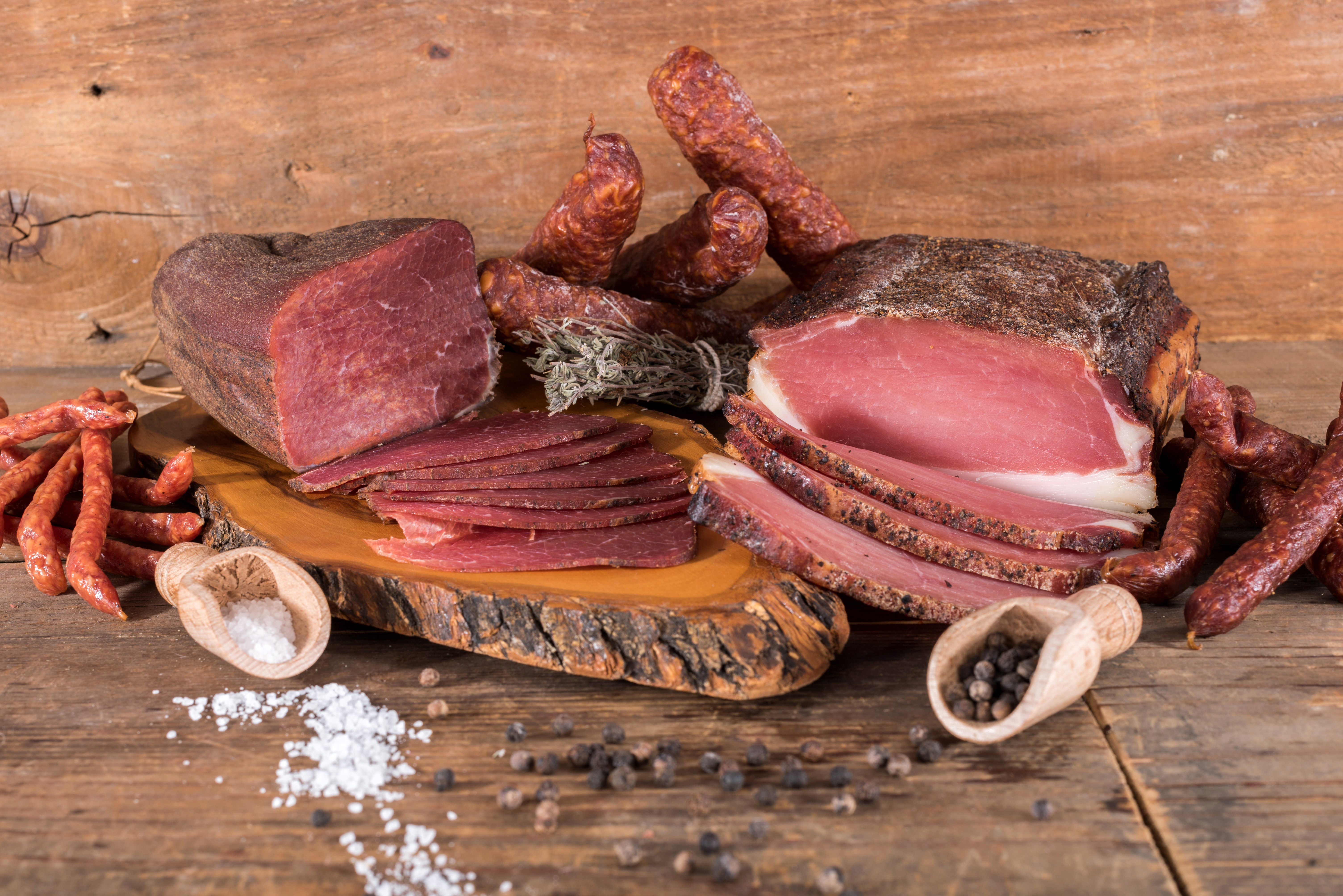 Meat products, ham, and sausage on a wooden table HD Wallpaper