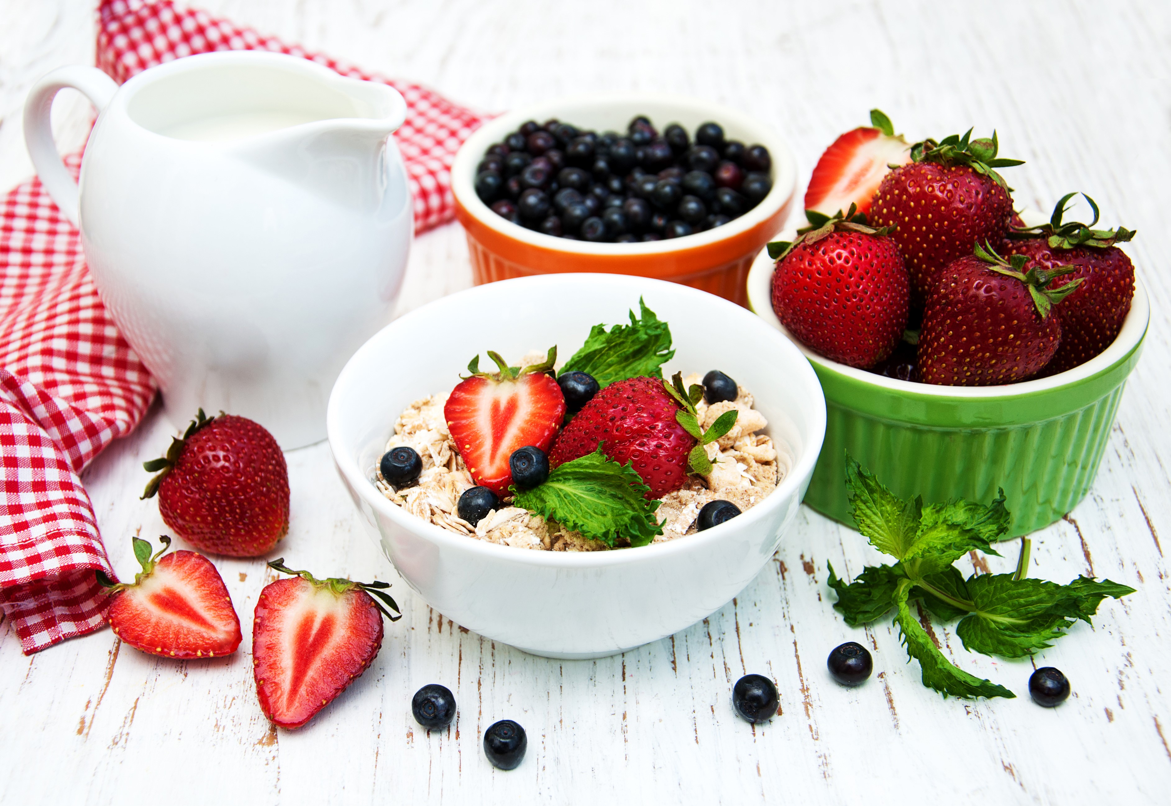 Muesli with strawberries and blueberries in a bowl with milk jug HD Wallpaper