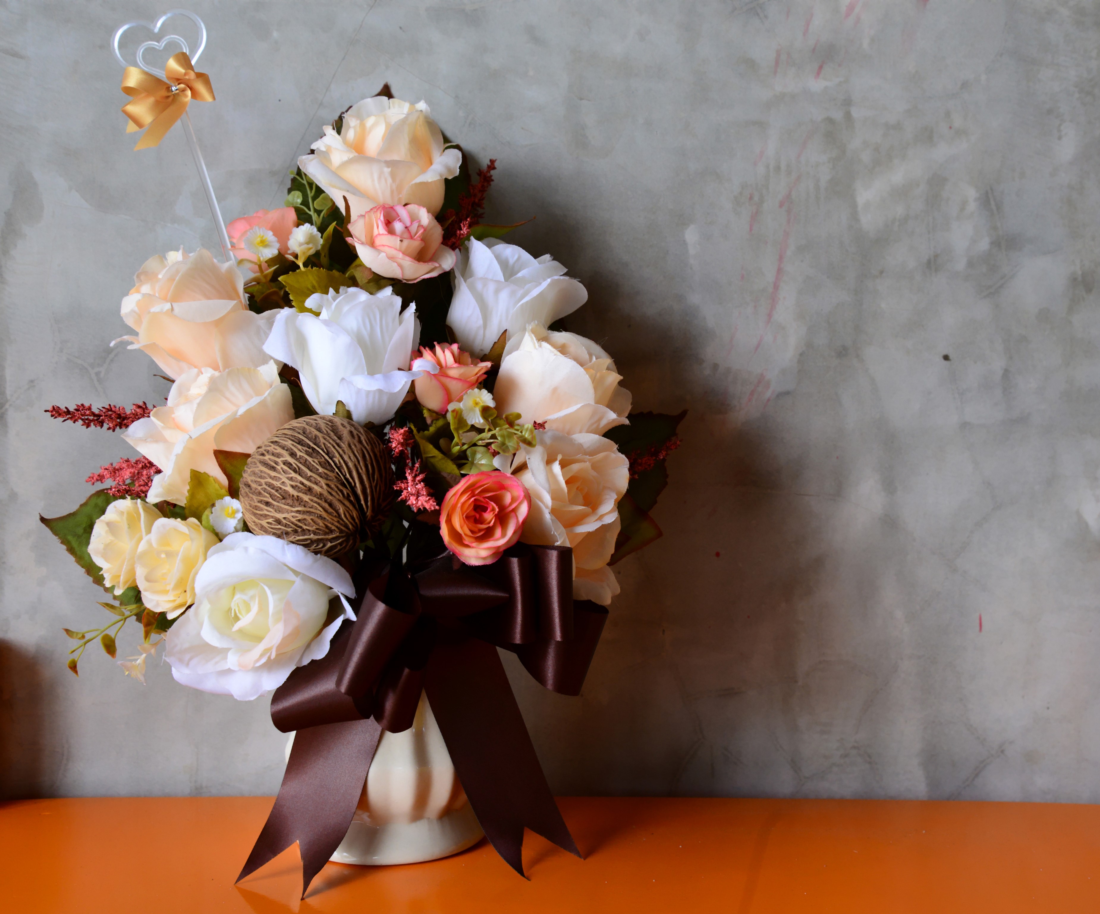 Artificial flower bouquet with a heart topper and bow HD Wallpaper