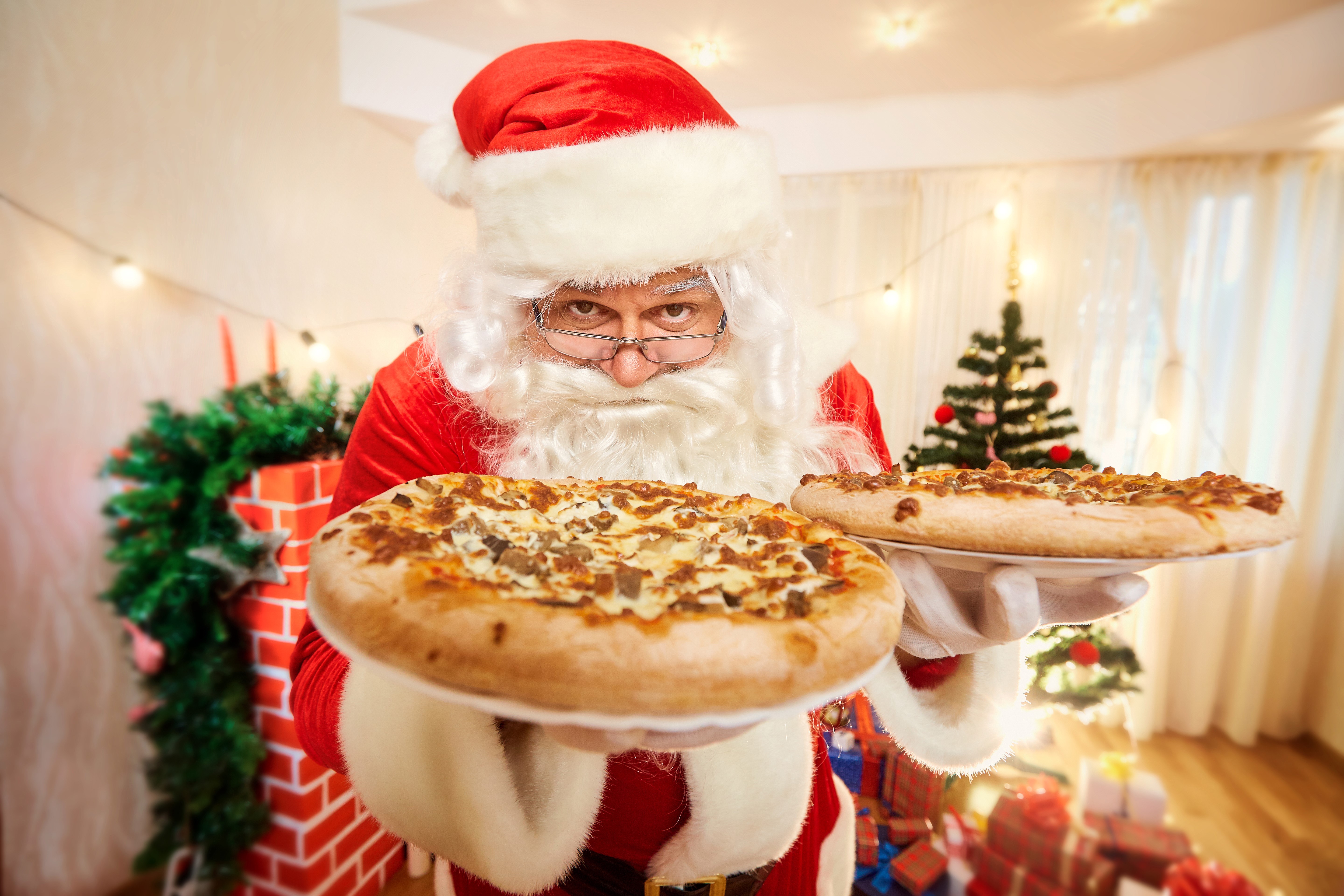 Santa Claus holding two pizzas HD Wallpaper