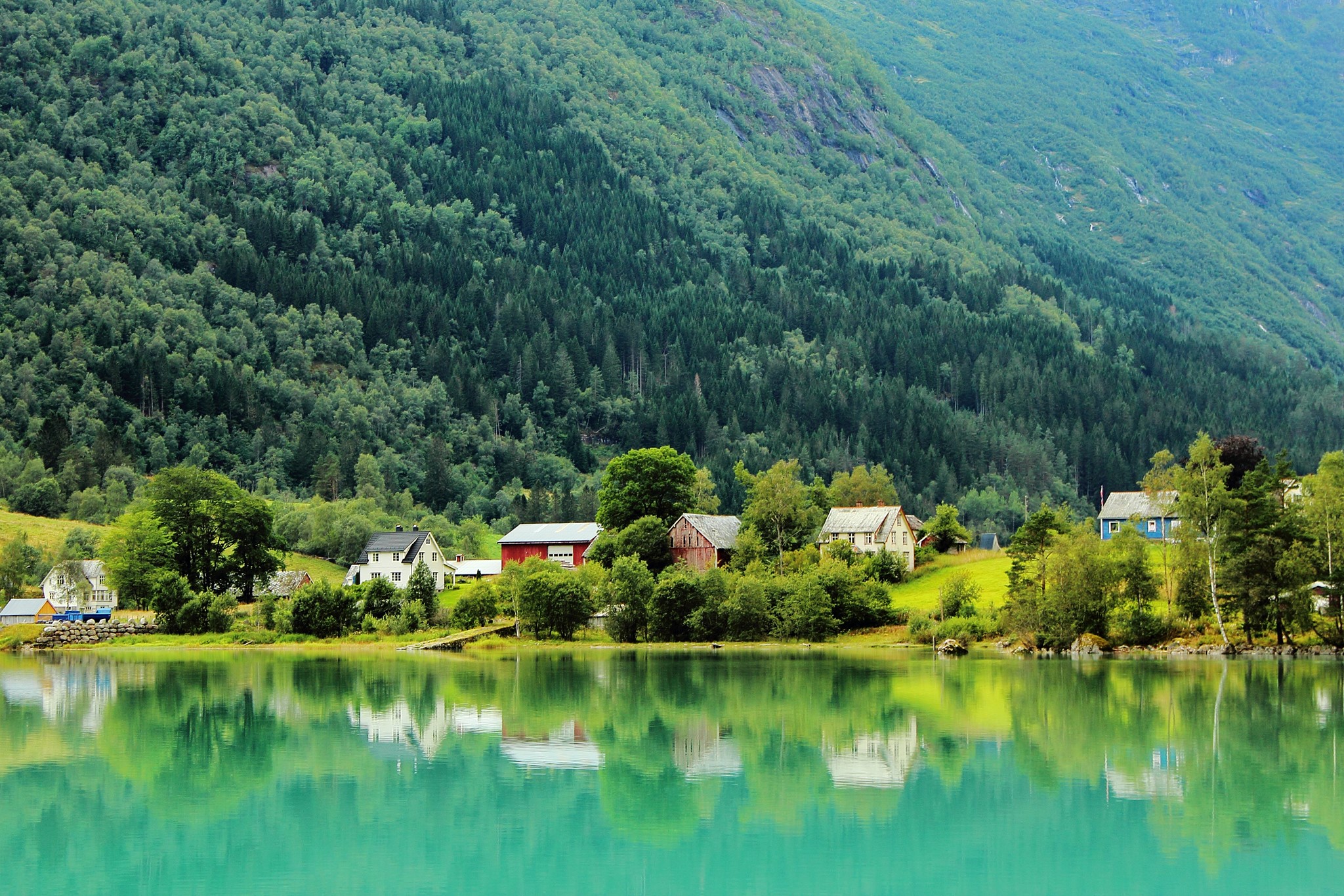 Houses by a lake with a forest-covered mountain in Faleide, Norway HD Wallpaper