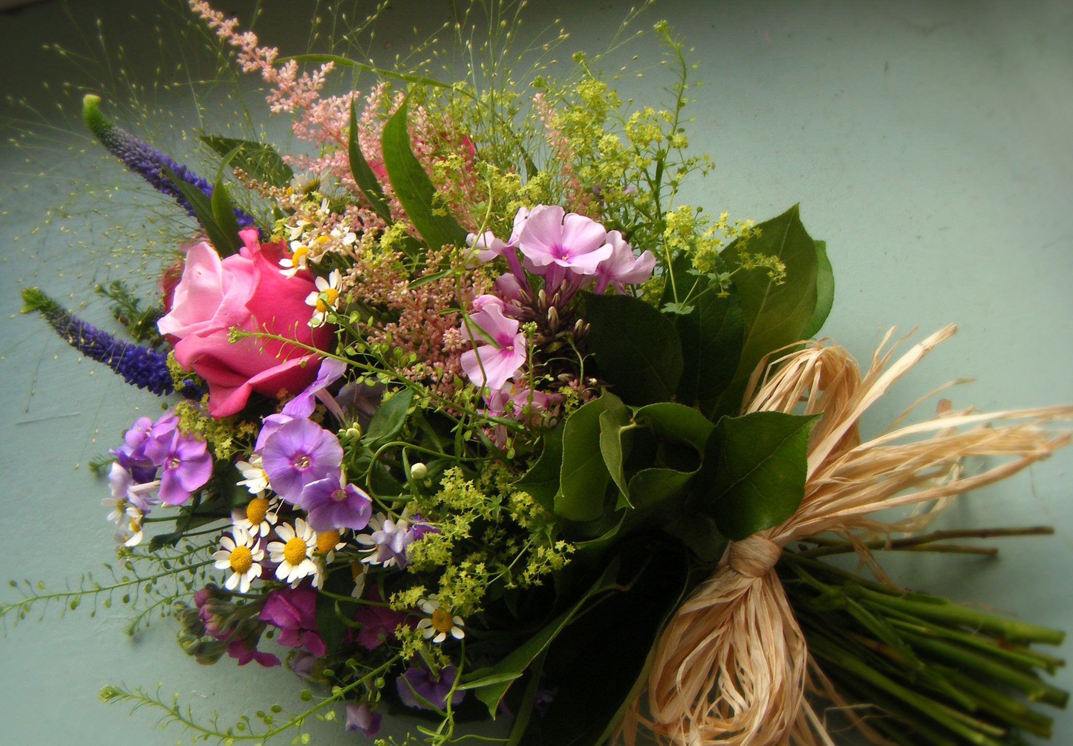 A bouquet of roses, phlox, and wildflowers tied with raffia HD Wallpaper